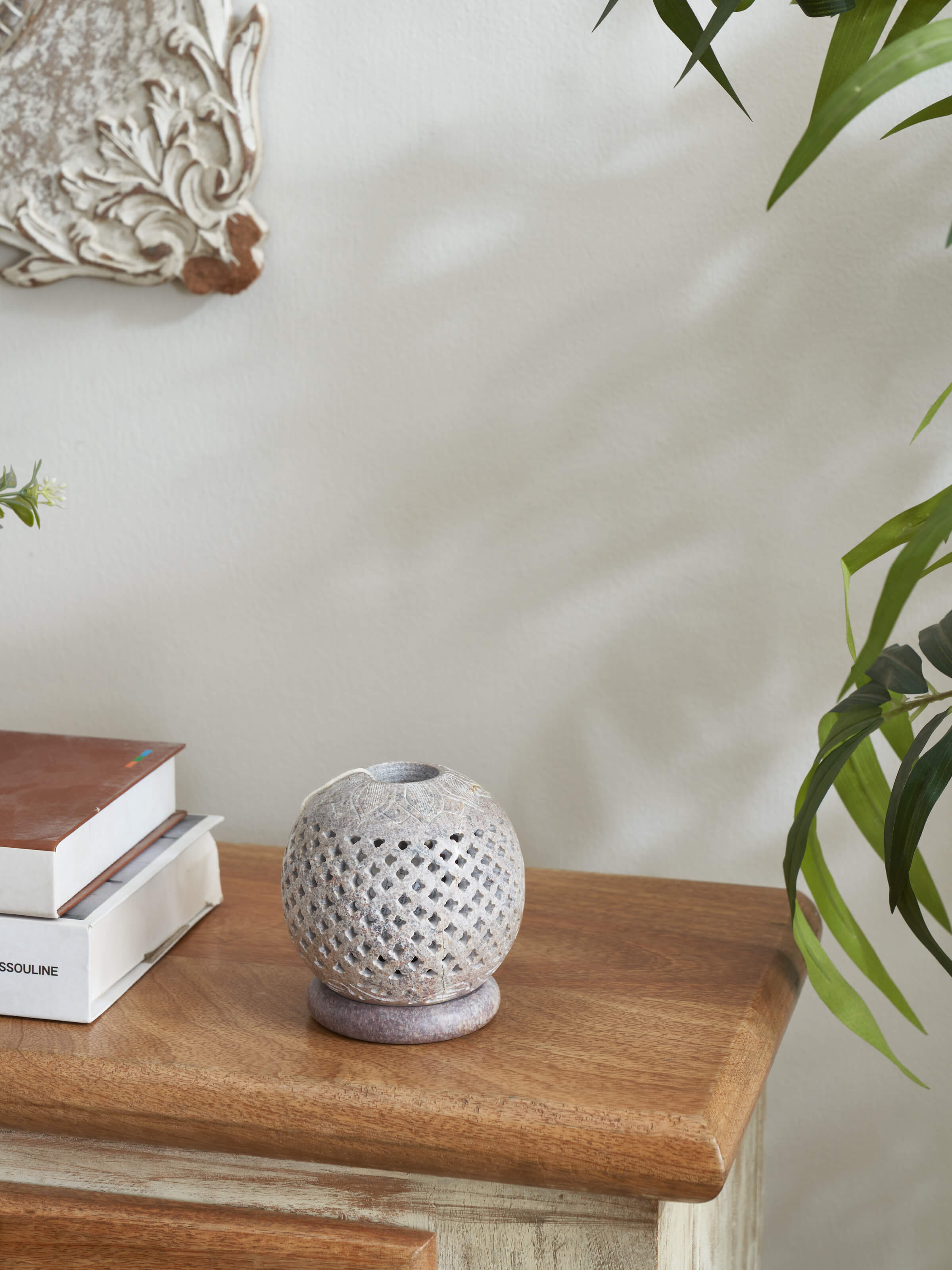 Side view of carved stone tea light holder, highlighting the detailed stonework