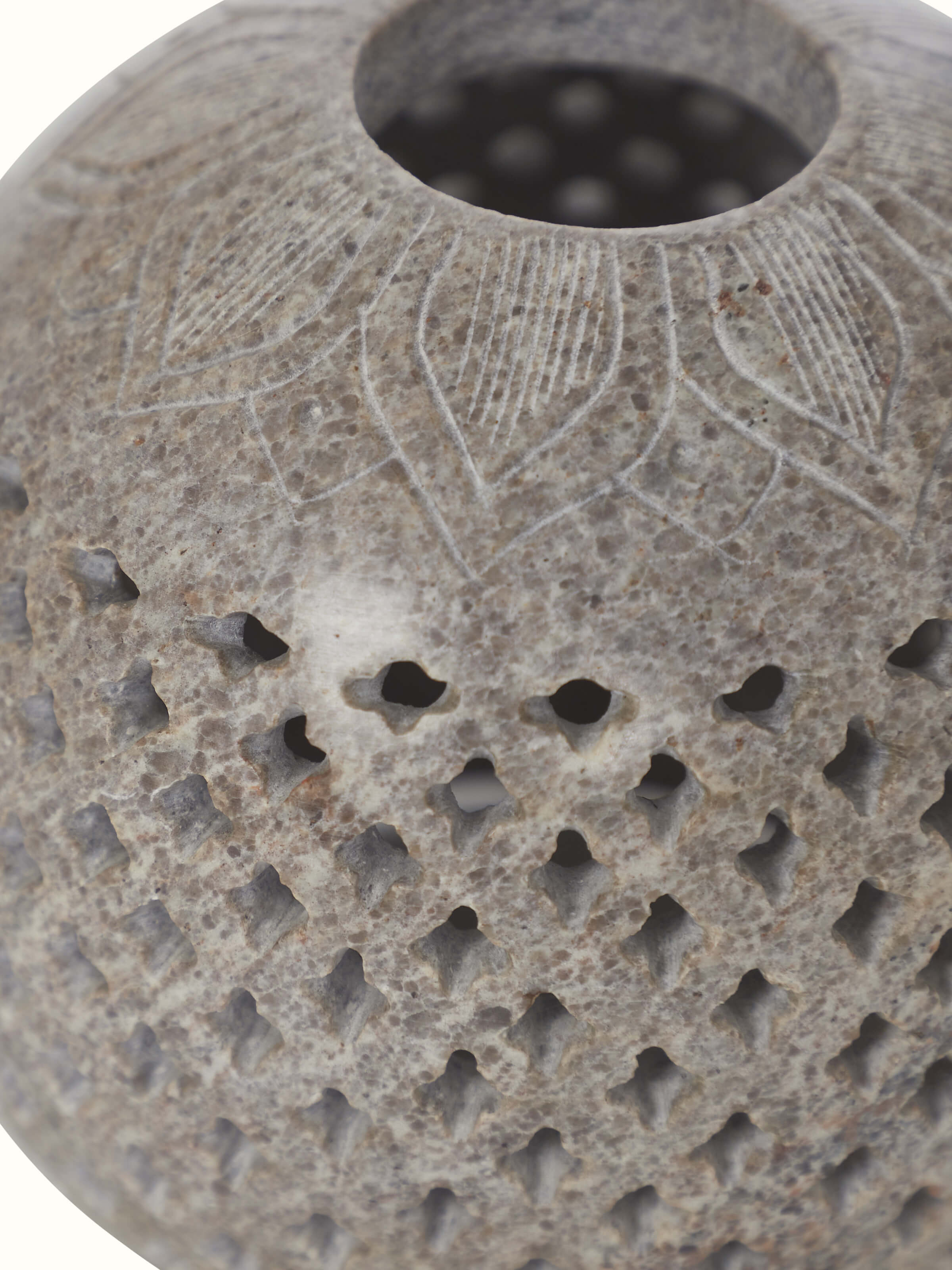 Close-up view of carved stone tea light holder, showcasing the fine carving details