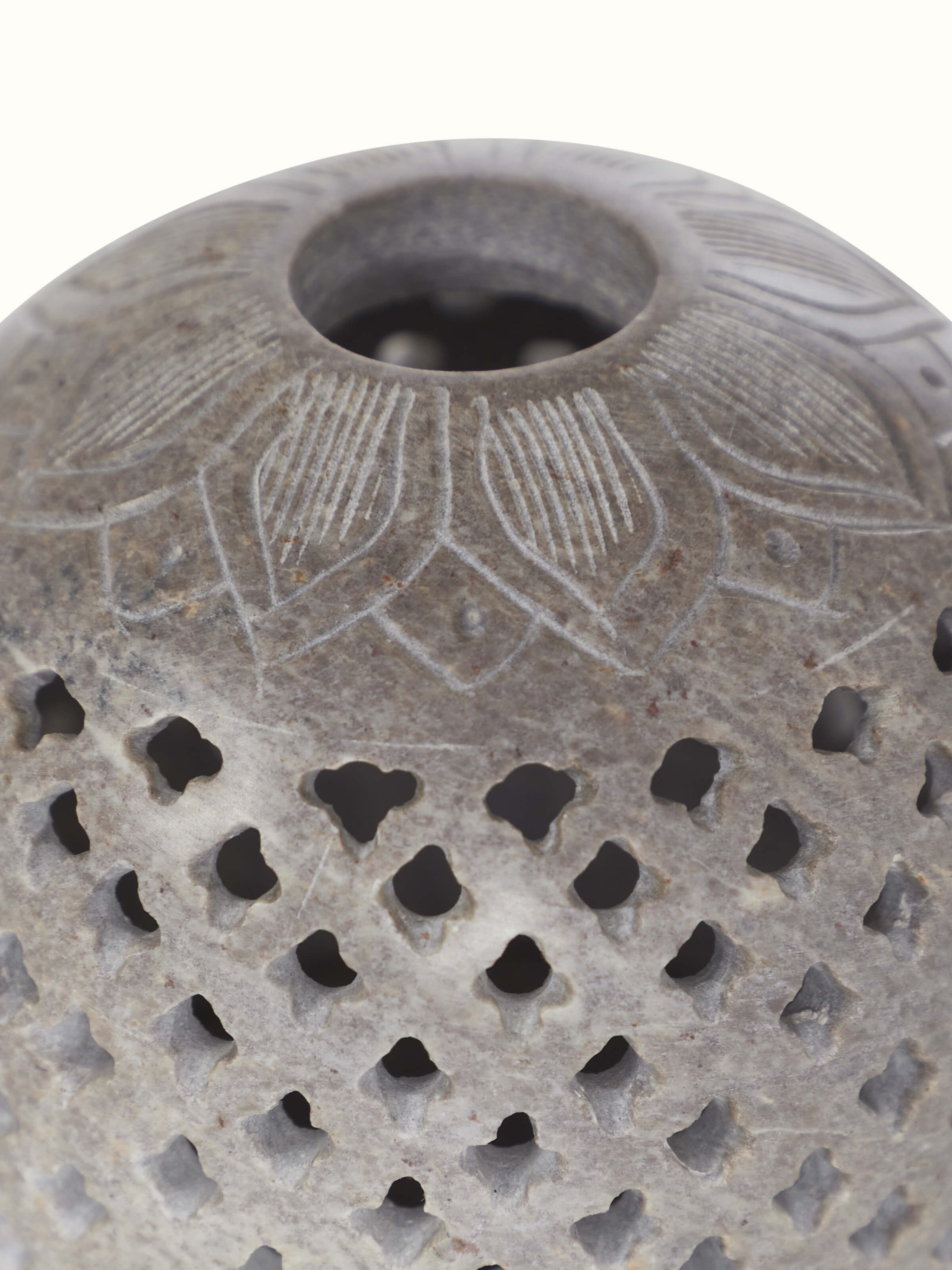 Top-down view of natural carved stone tea light holder, showing its intricate carving and functionality.