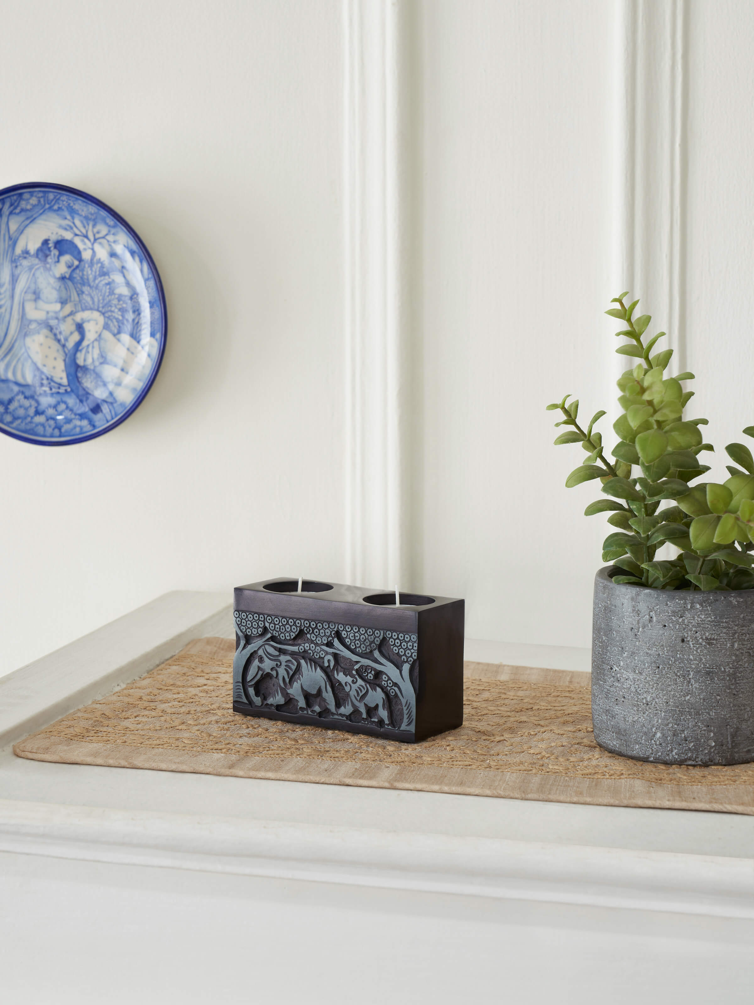 Side view of Transitional Carved Stone Tea Light Holder, showing the detailed stonework and functional design.