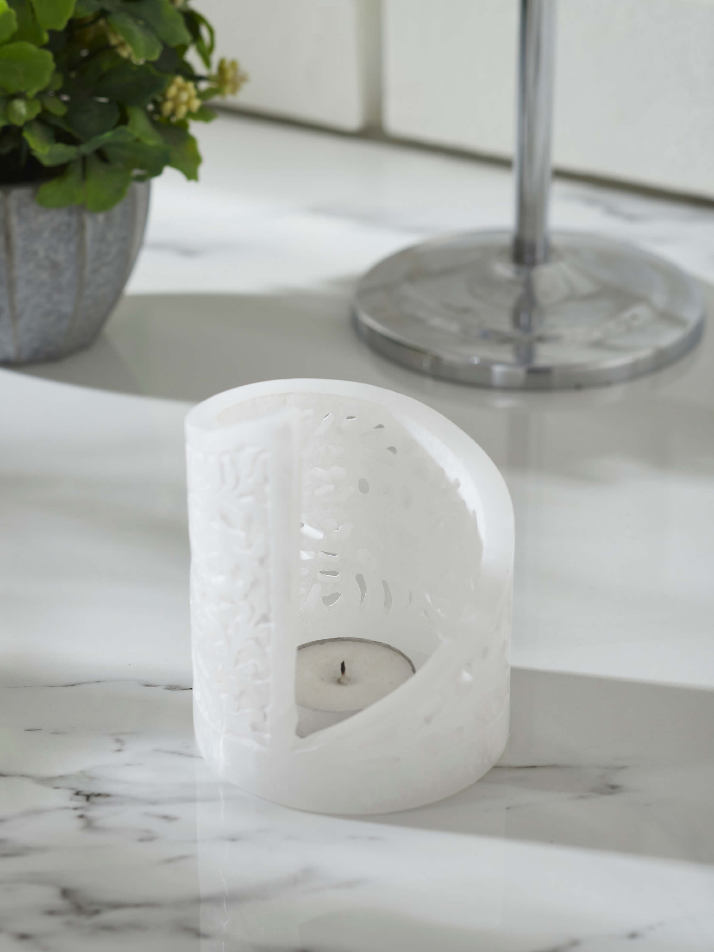 Side view of polished carved soapstone tea light holder, showcasing the elegant design and smooth texture.