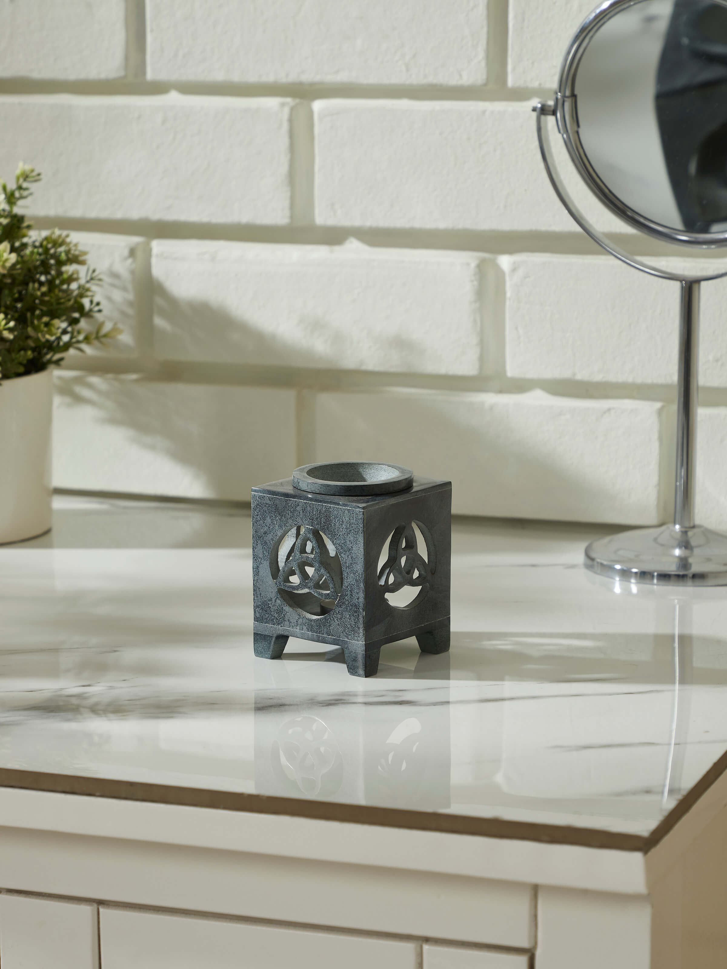 Close-up view of carved soapstone aroma oil burner & diffuser in black color focusing on the intricate carving details