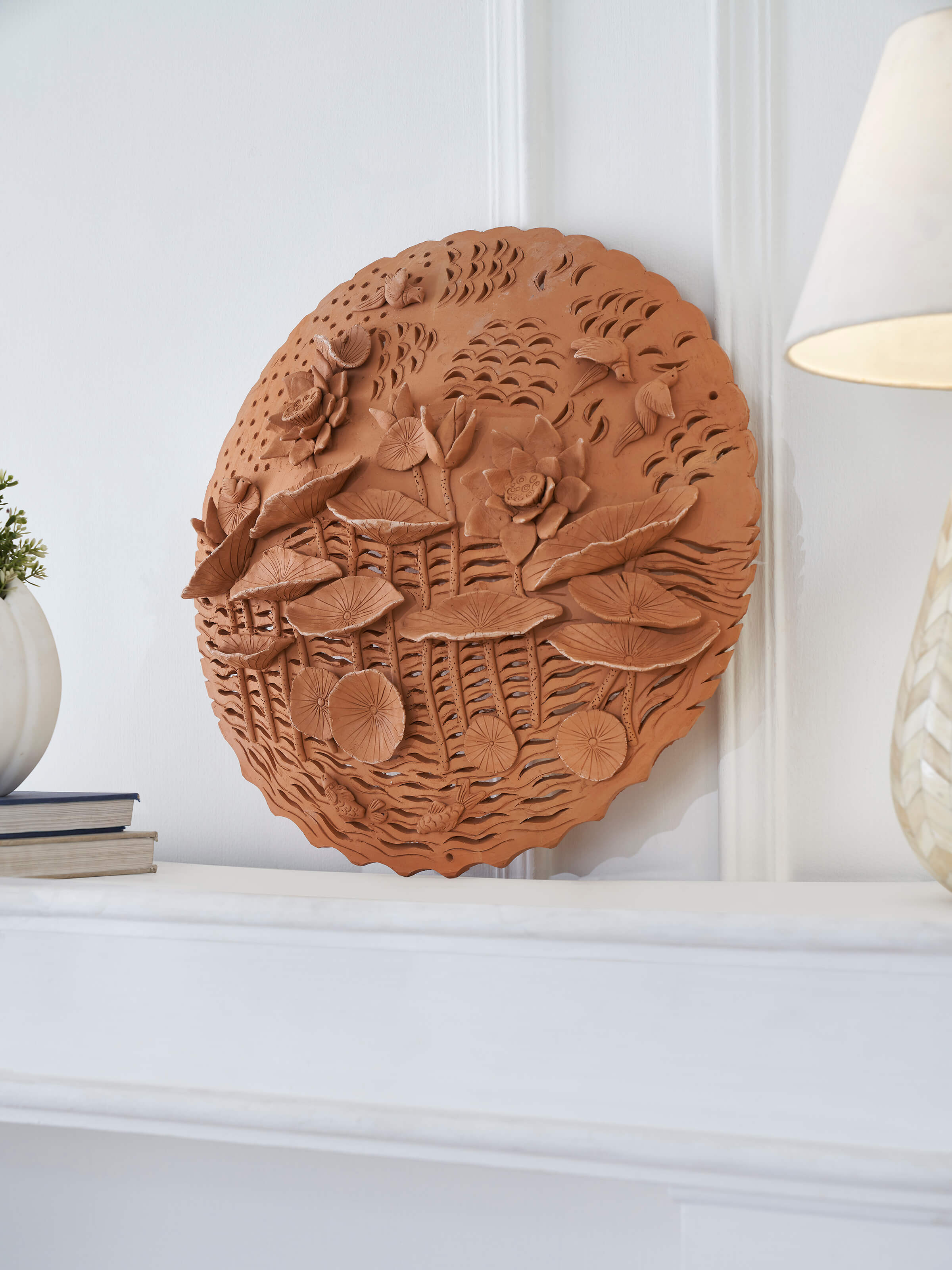 Top view of terracotta clay lotus cutout sculpture plate emphasizing artistic craftsmanship