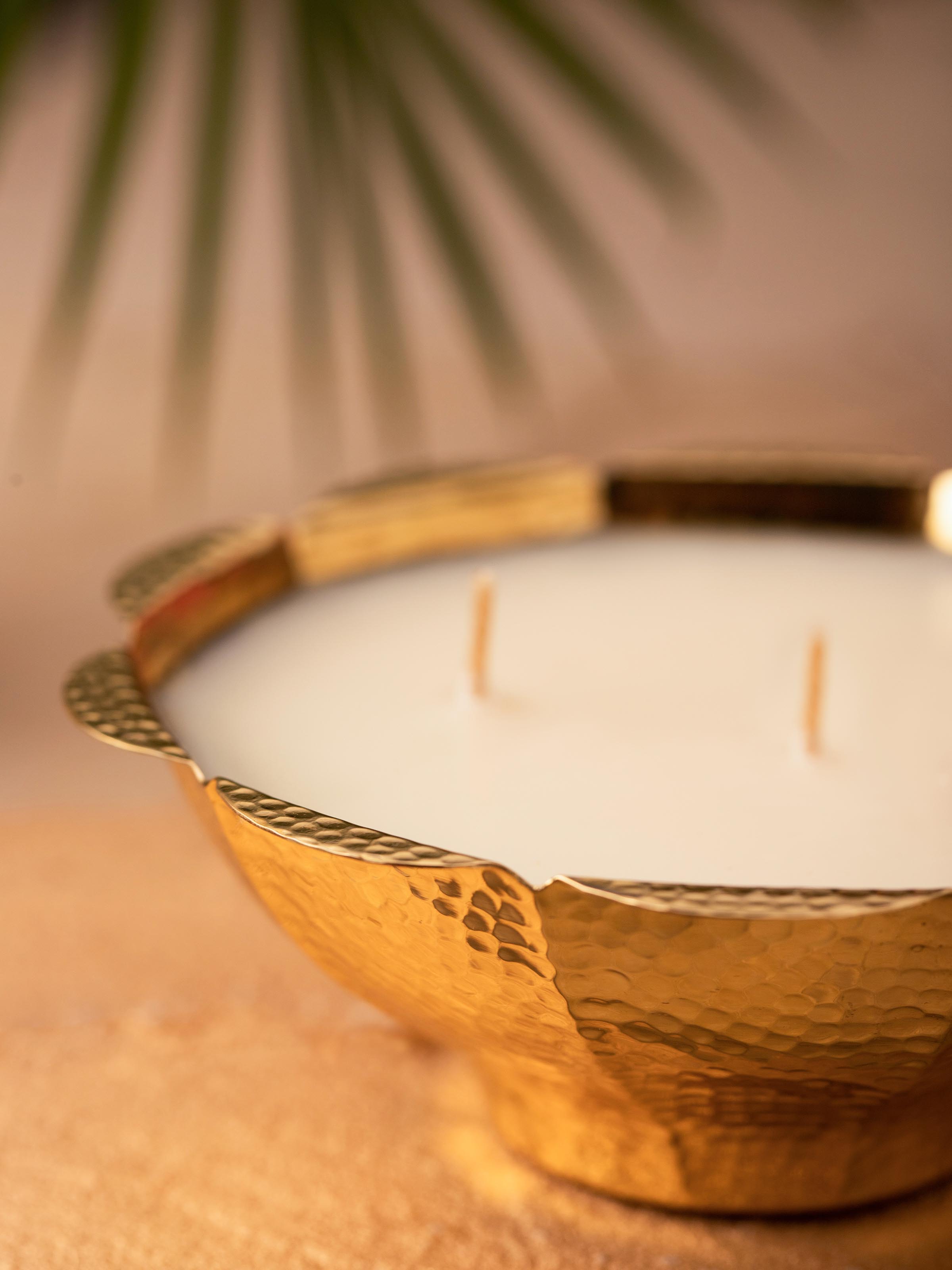 Side view of the brass candle with two wicks, emphasizing its sturdy construction.