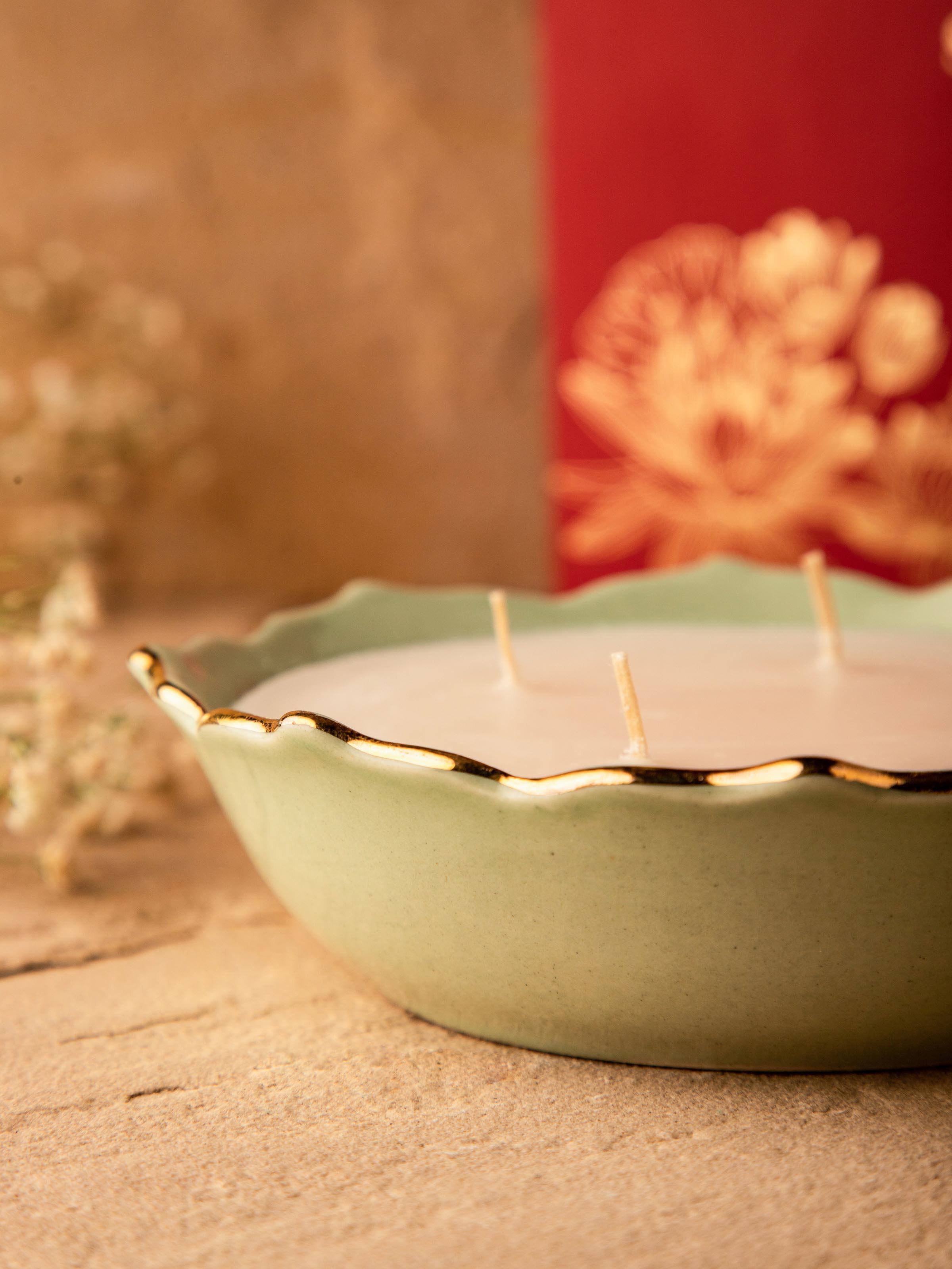 Close-up of Green Ceramic Candle emphasizing the intricate design details and warm glow