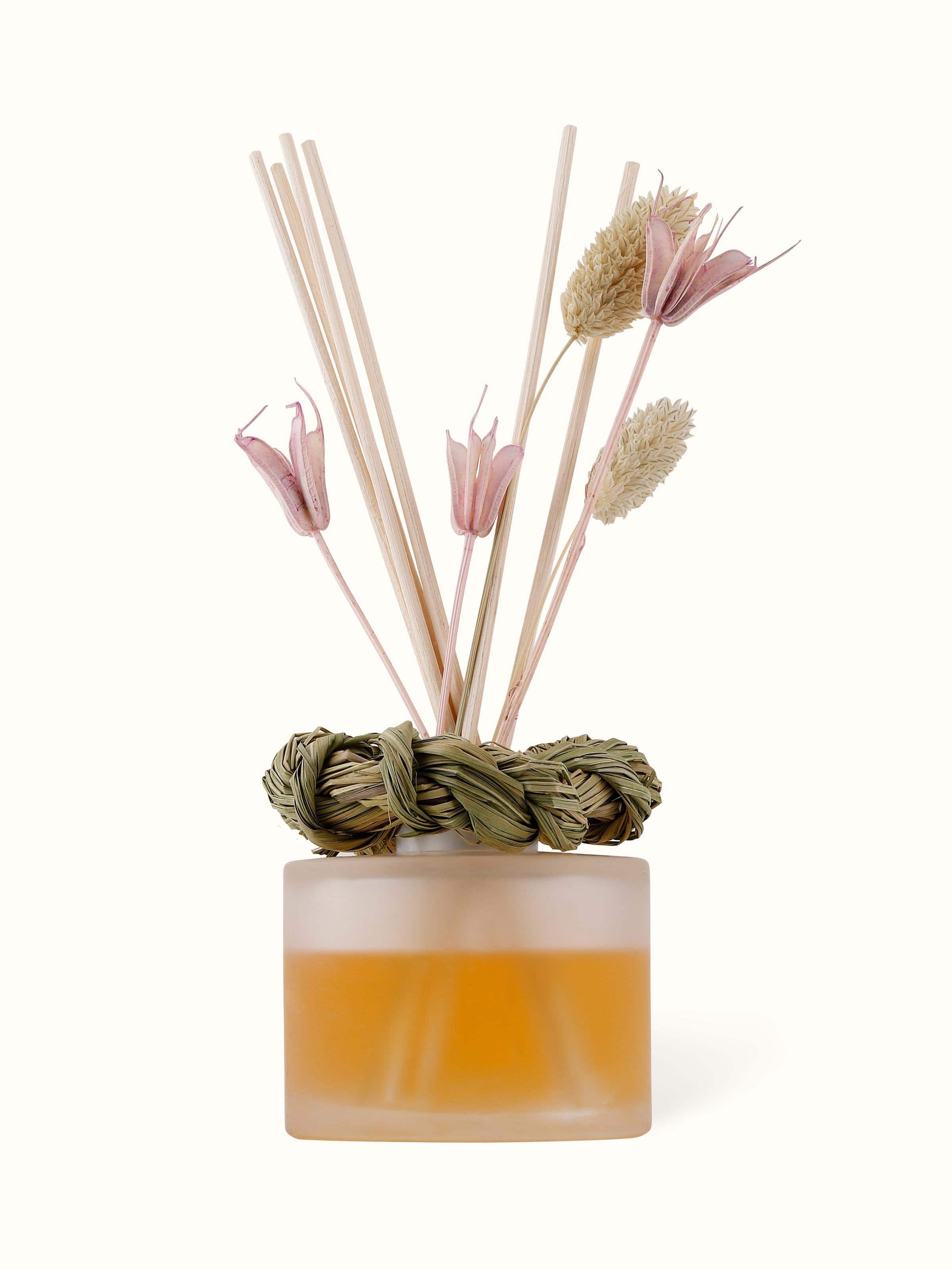 Lavender aroma reed diffuser with a clear glass bottle and lavender-colored reeds.