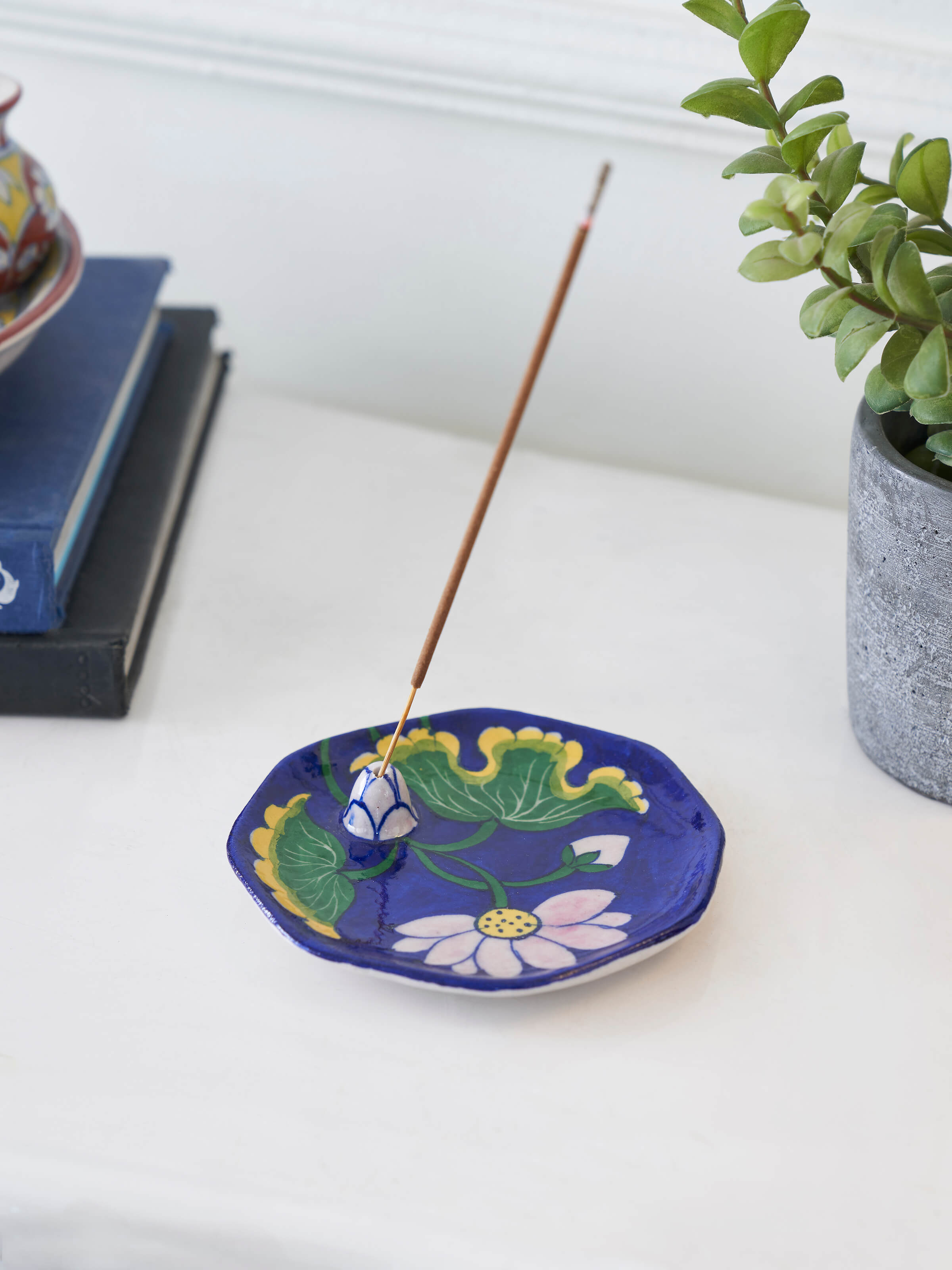 Side view of blue pottery stoneware lotus incense stick holder highlighting its unique design