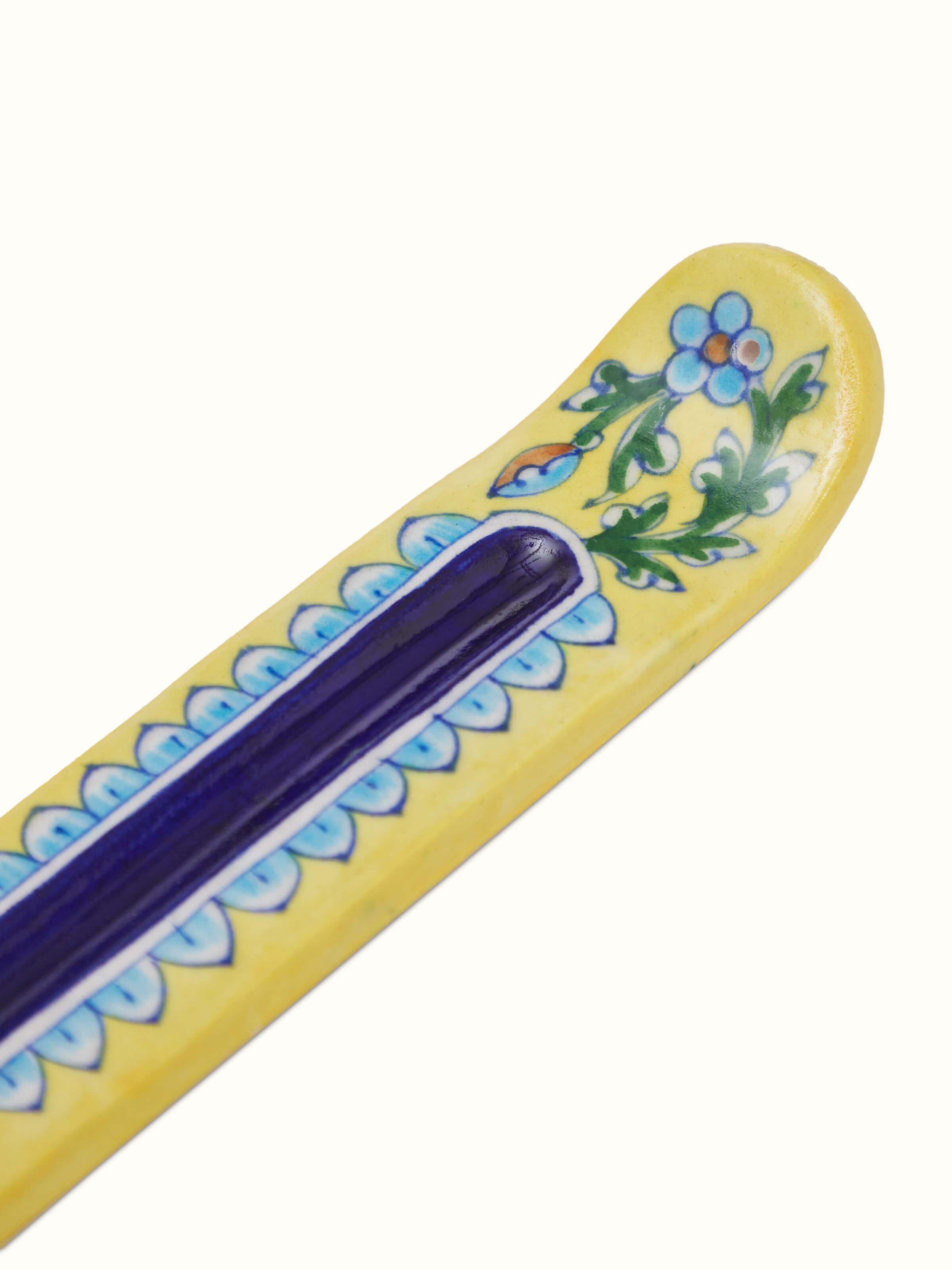 Detailed view of blue pottery stoneware incense holder in yellow color, focusing on the intricate patterns and texture.