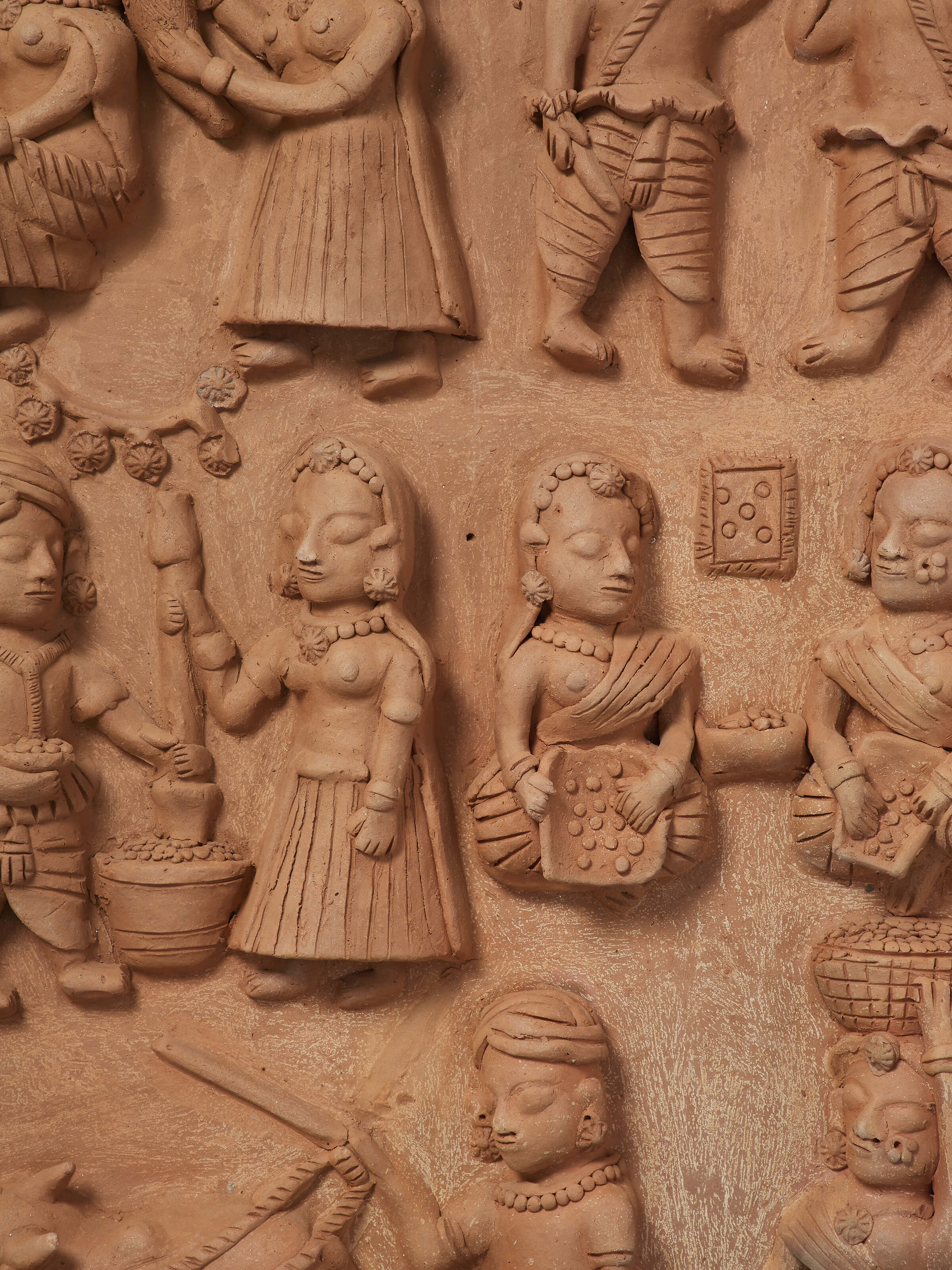 Close-up of terracotta clay village scene sculpture focusing on detailed artwork and texture