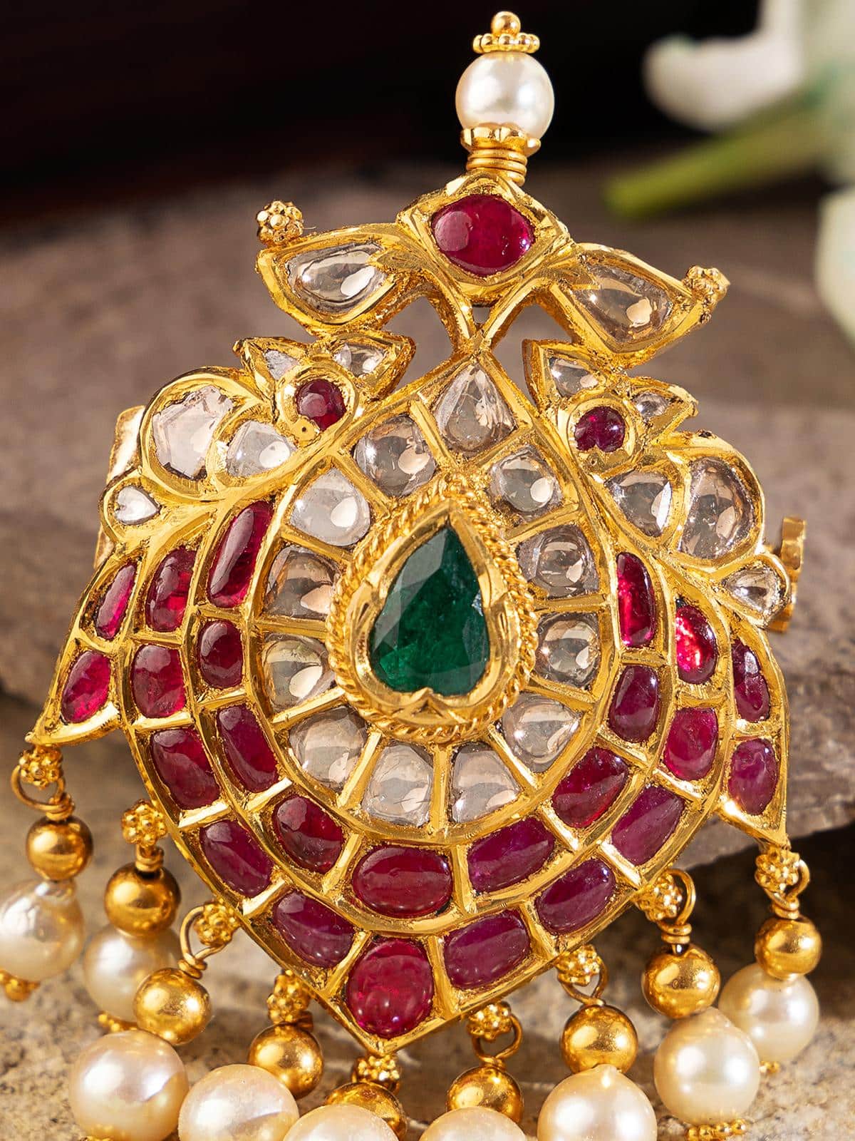Close-up of 22k gold Jadau brooch focusing on handcrafted detailing and vintage appeal