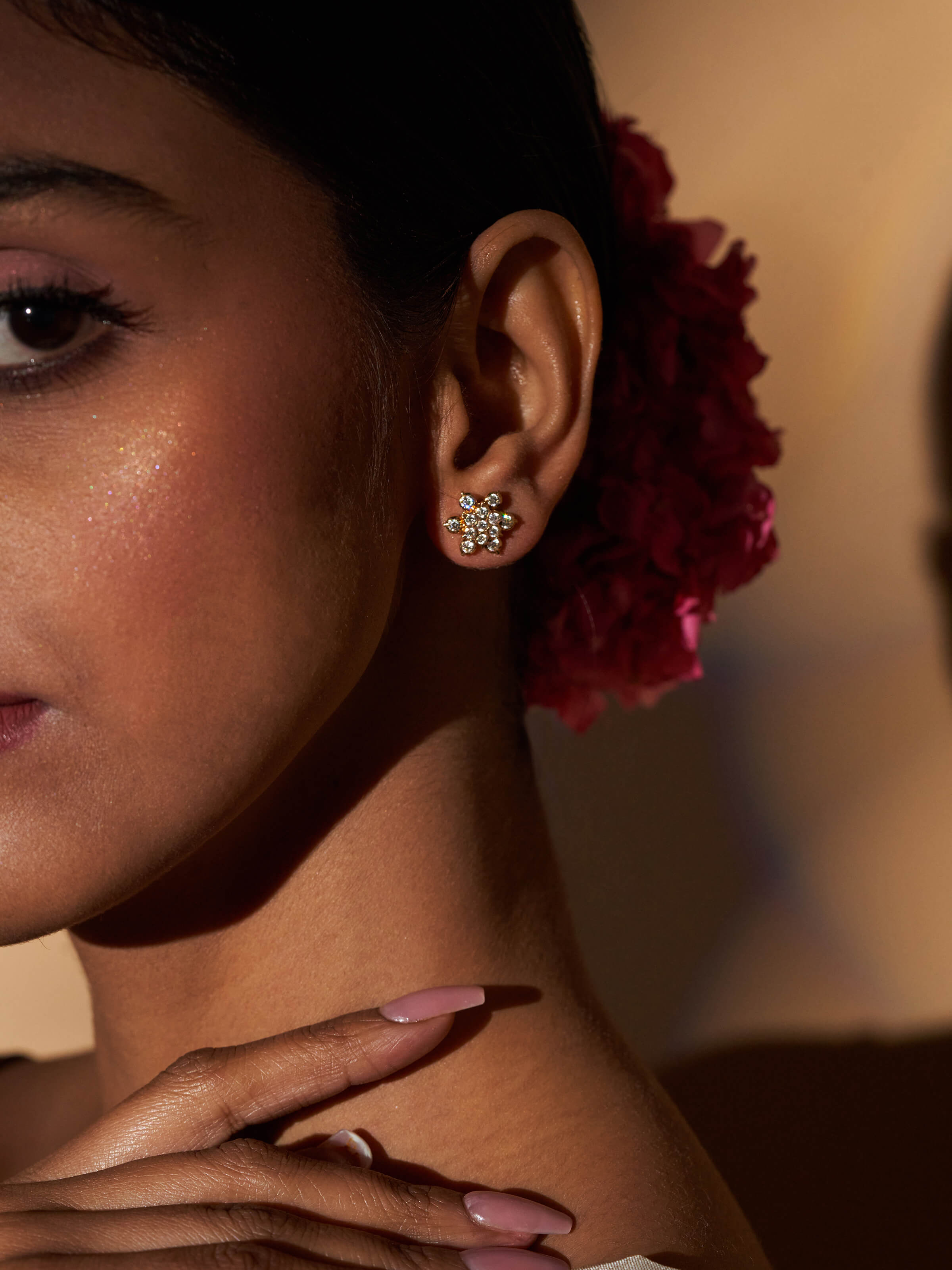 Lifestyle shot of gold studs worn on ear with traditional festive styling