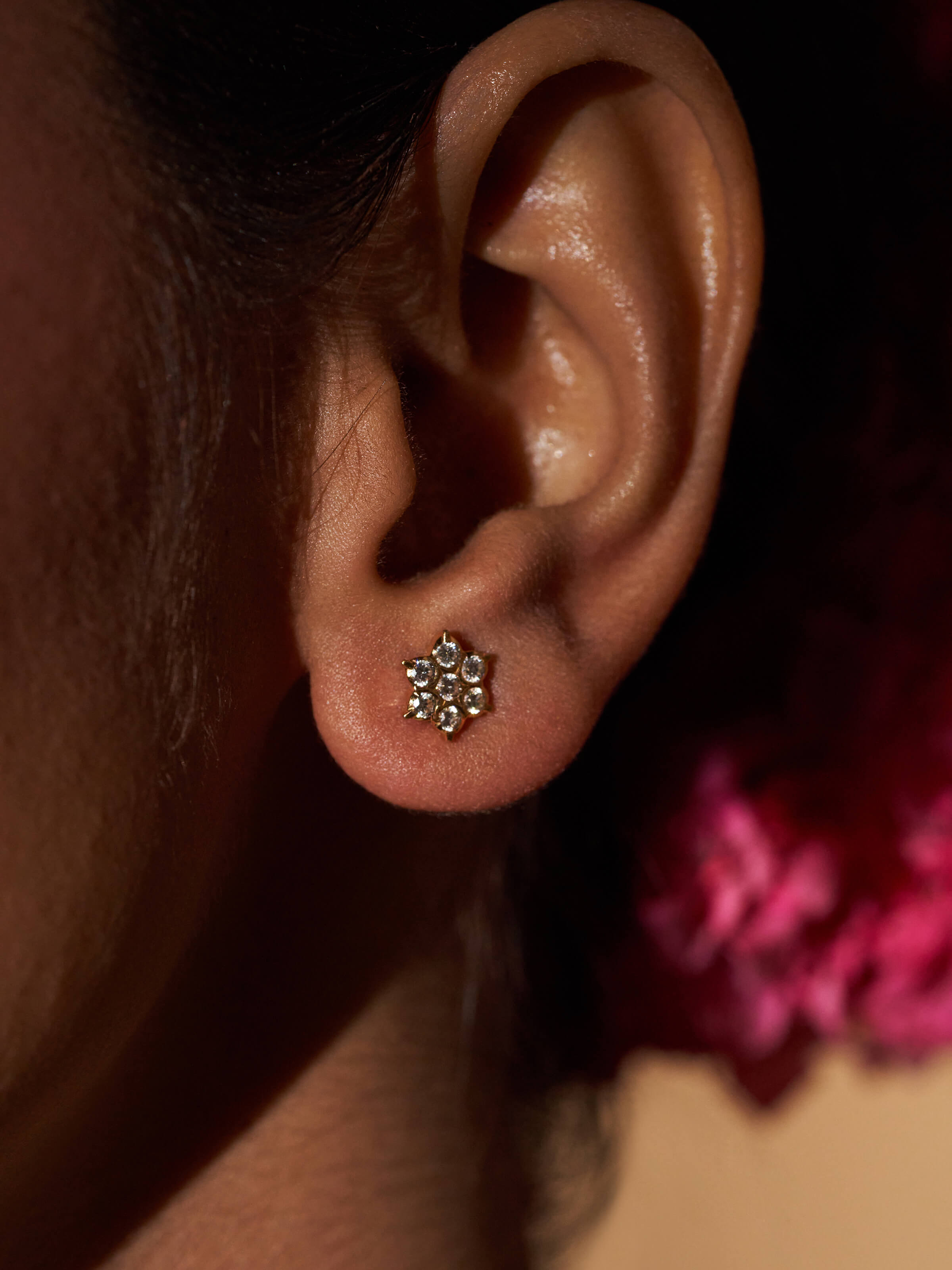 Angled lifestyle view of gold studs showing rich tone and secure fitting