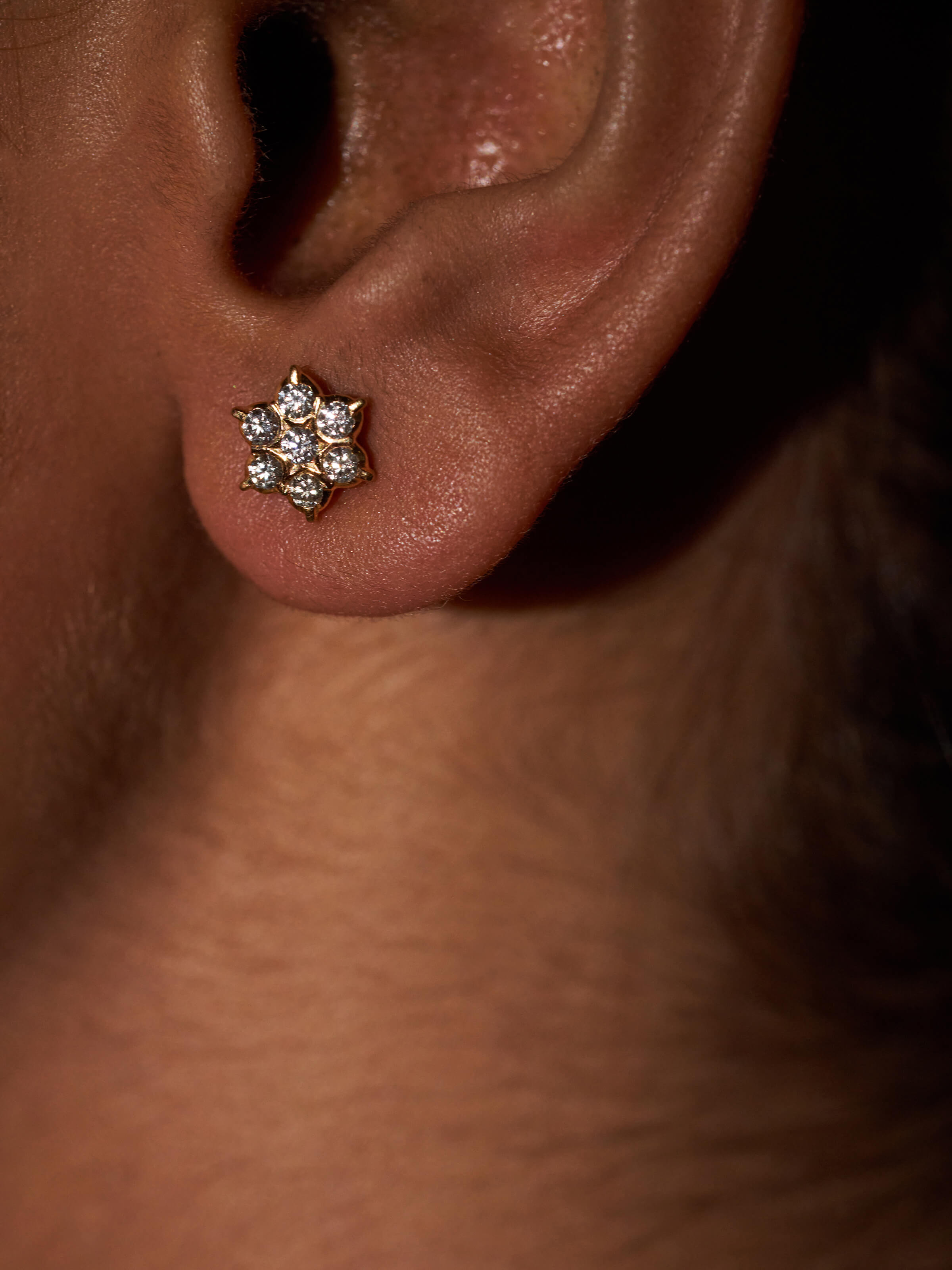 Detail shot of gold studs revealing refined setting and high-polish finish