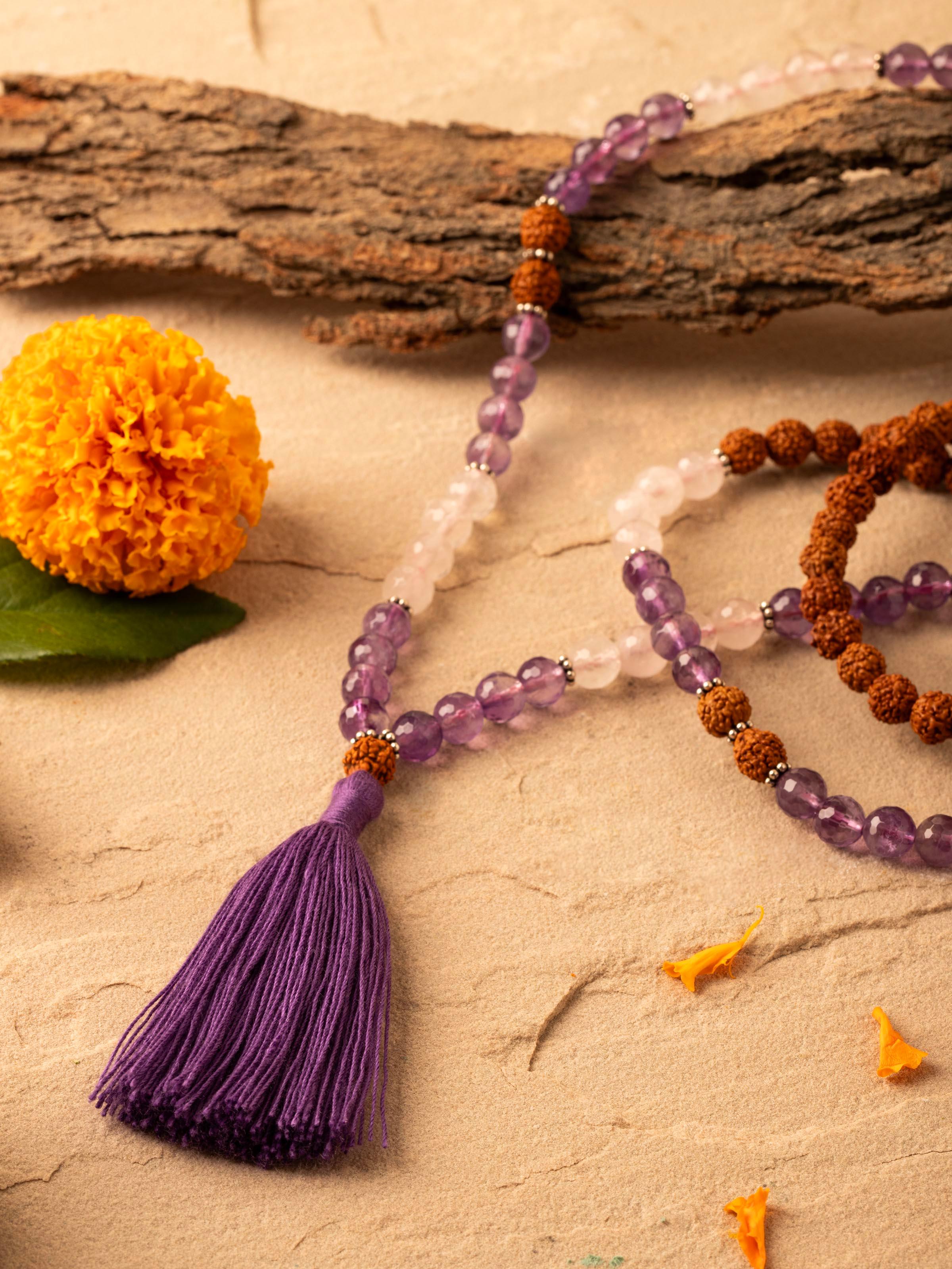 Close-up of Amethyst, Rose Quartz & Rudraksha Silver Mala focusing on the texture and color variations of the beads.