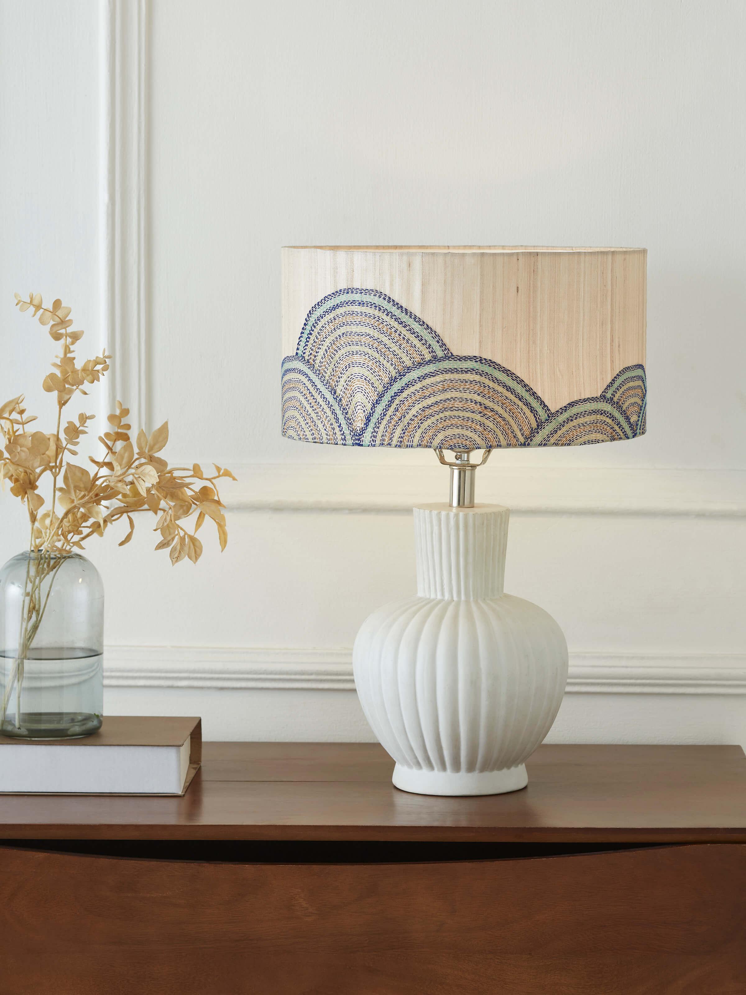 Side view of Sujani hand-embroidered cotton lampshade in beige color showcasing detailed stitching