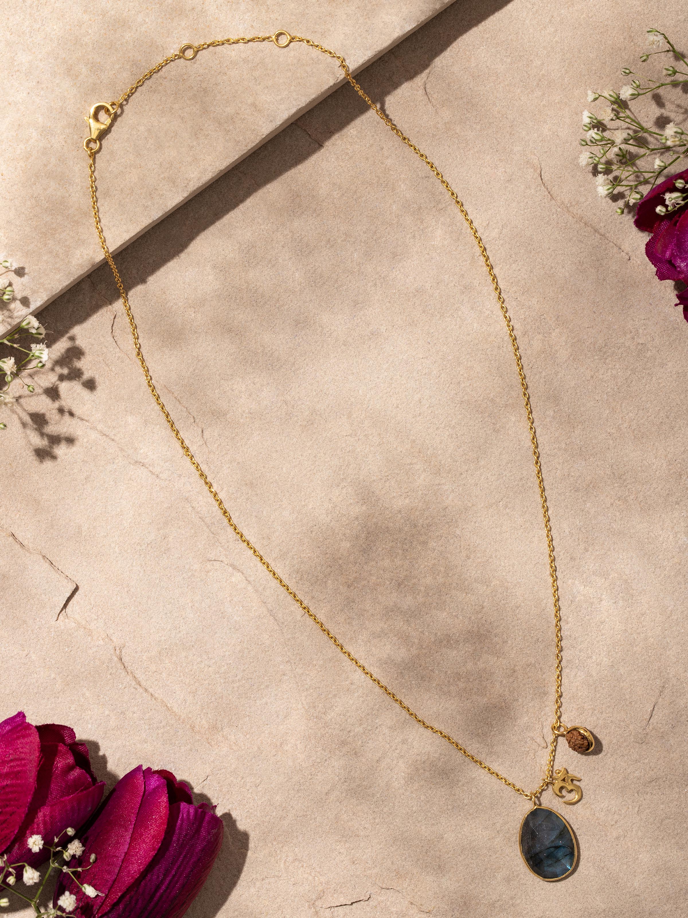 Detailed view of Labradorite, OM silver charm & Rudraksha necklace, highlighting the gold-plated sterling silver design.