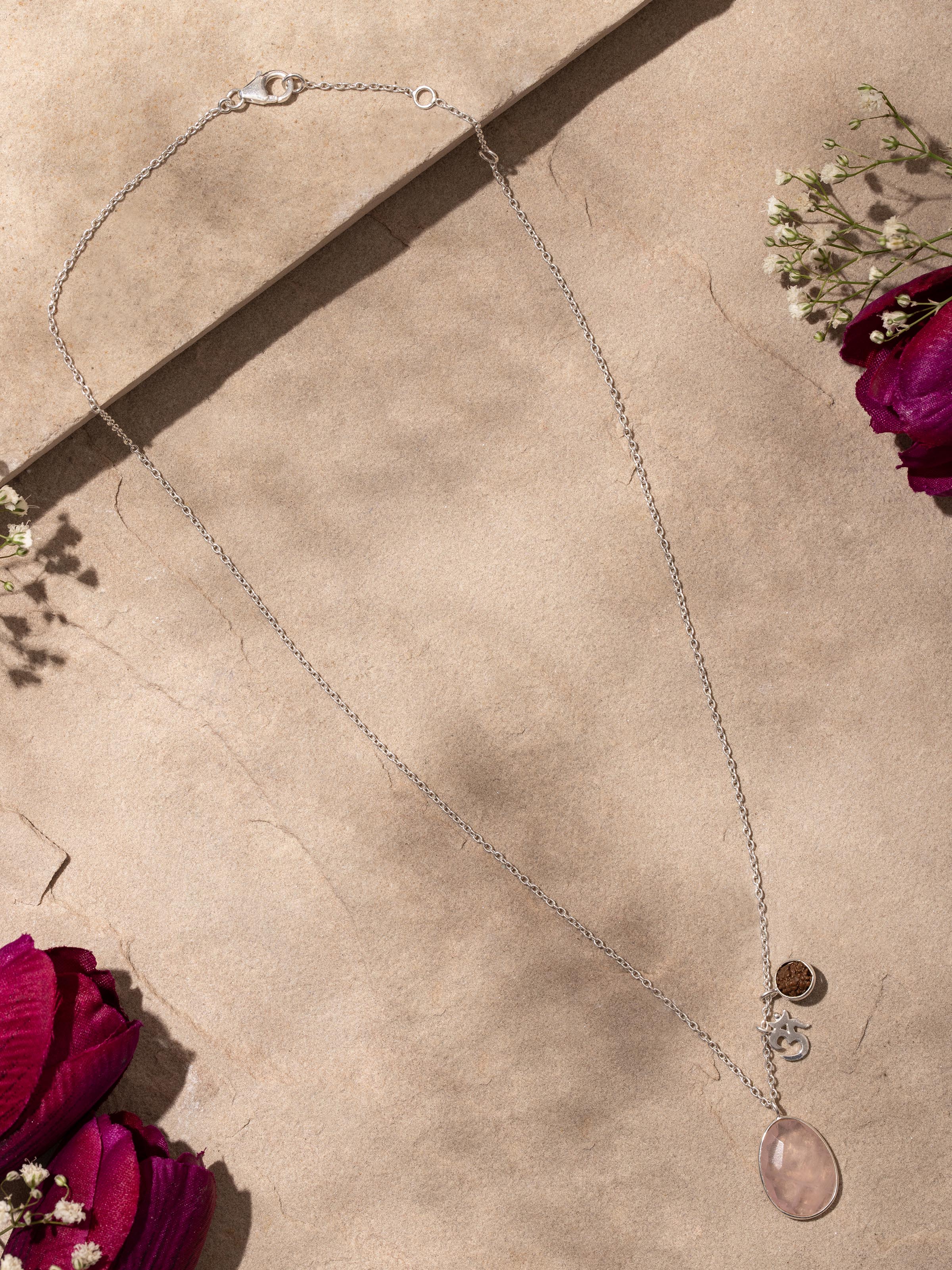 Front view of Rose Quartz, Om Silver Charm & Rudraksha Sterling Silver Necklace, showing the intricate charm and gemstone design.