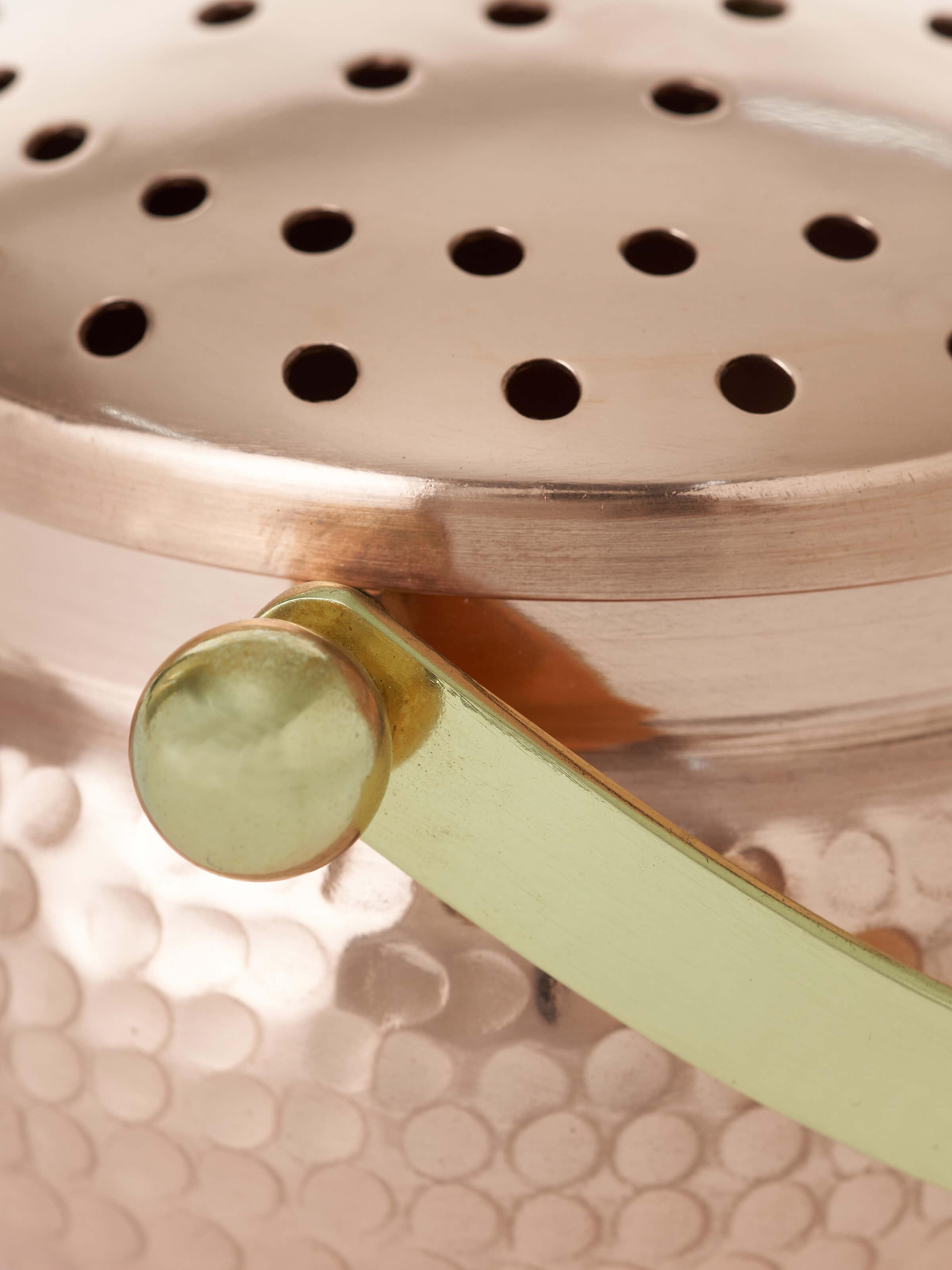 Angle view of Polished copperware dhuna small