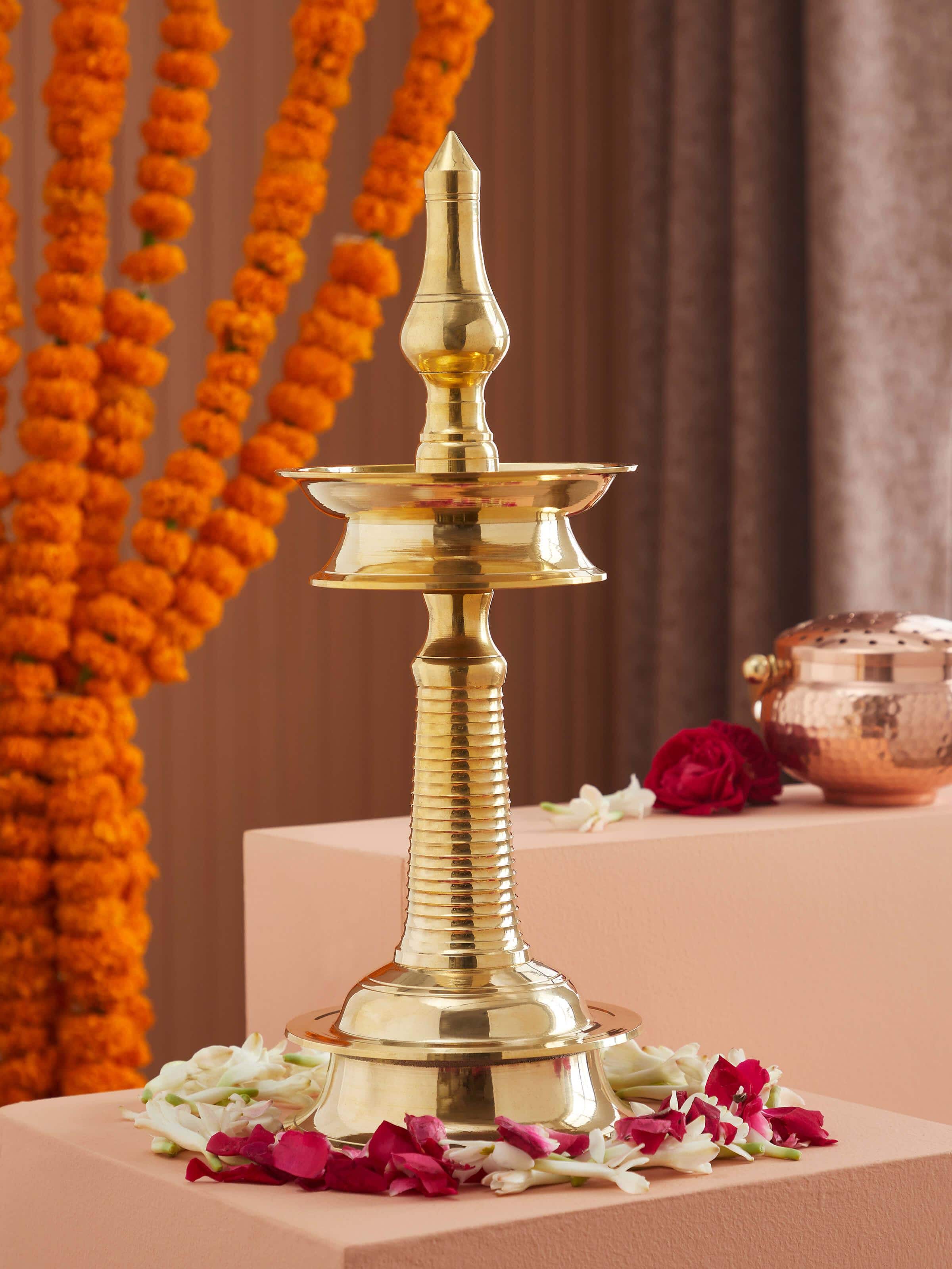 Close-up of brass kuthu vilakku stand diya, highlighting its polished finish and ornate patterns.