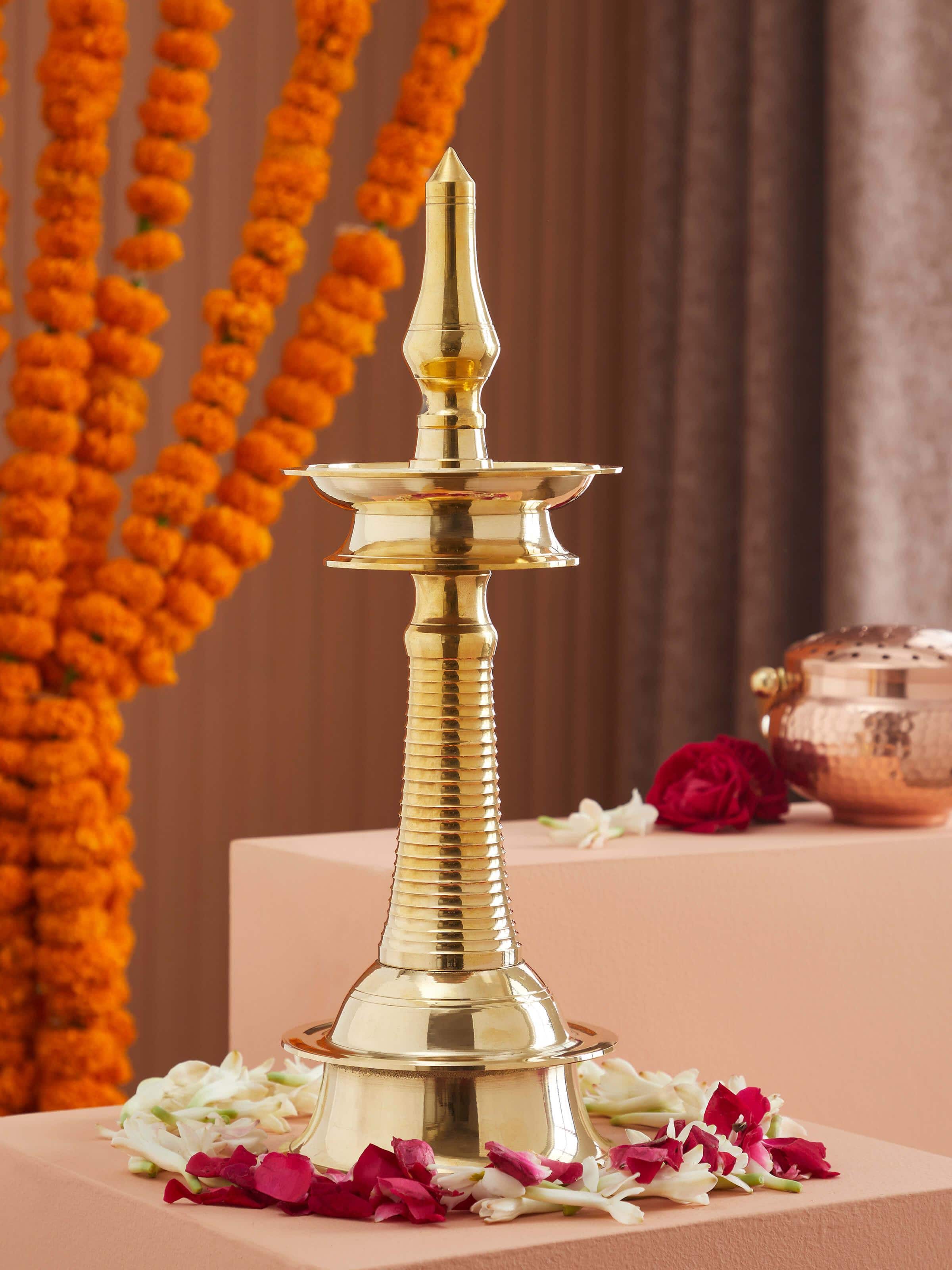 Side view of brass-plated kuthu vilakku stand diya with elegant design