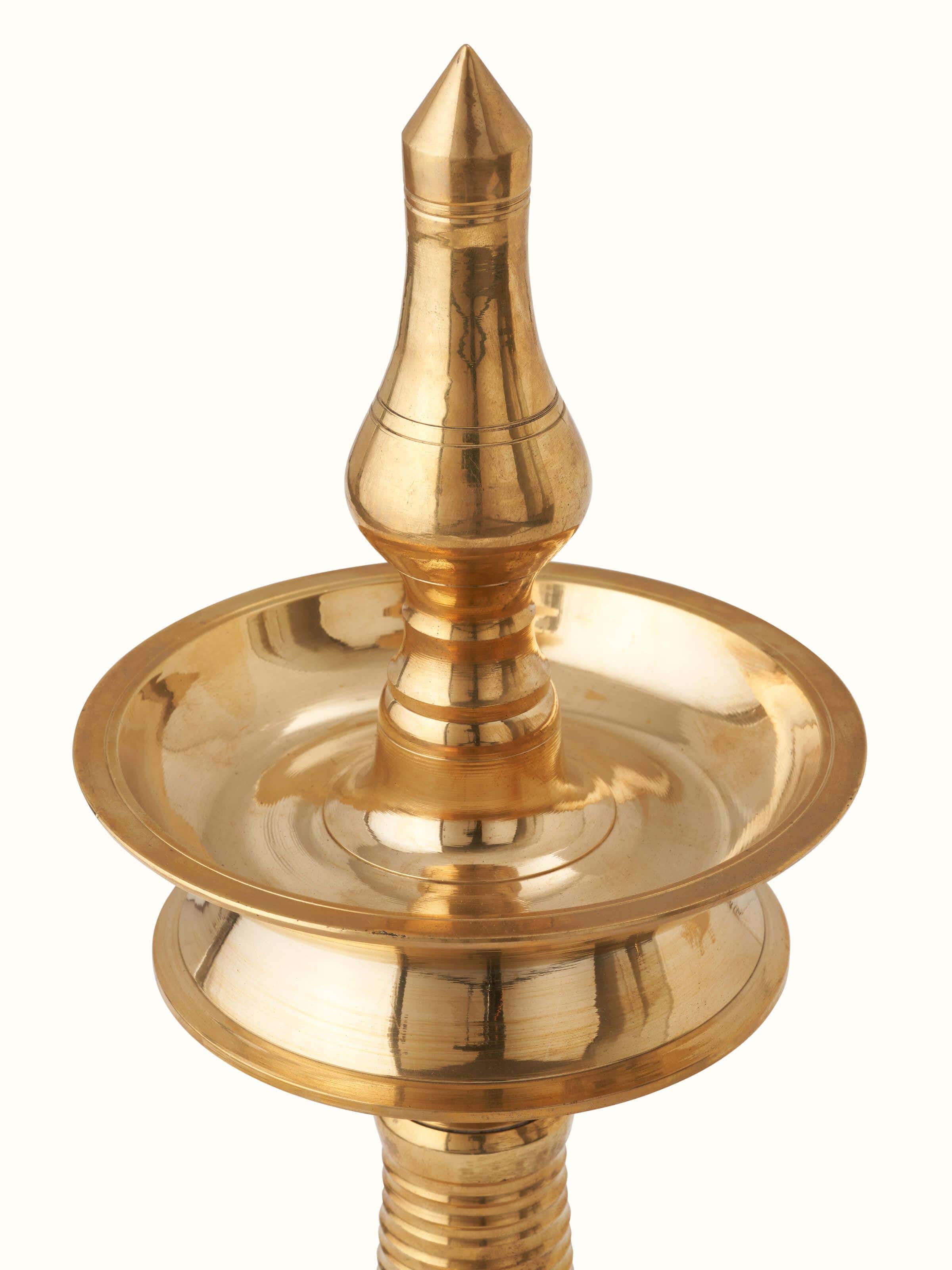 Detailed view of brass-plated kuthu vilakku stand diya showing intricate patterns