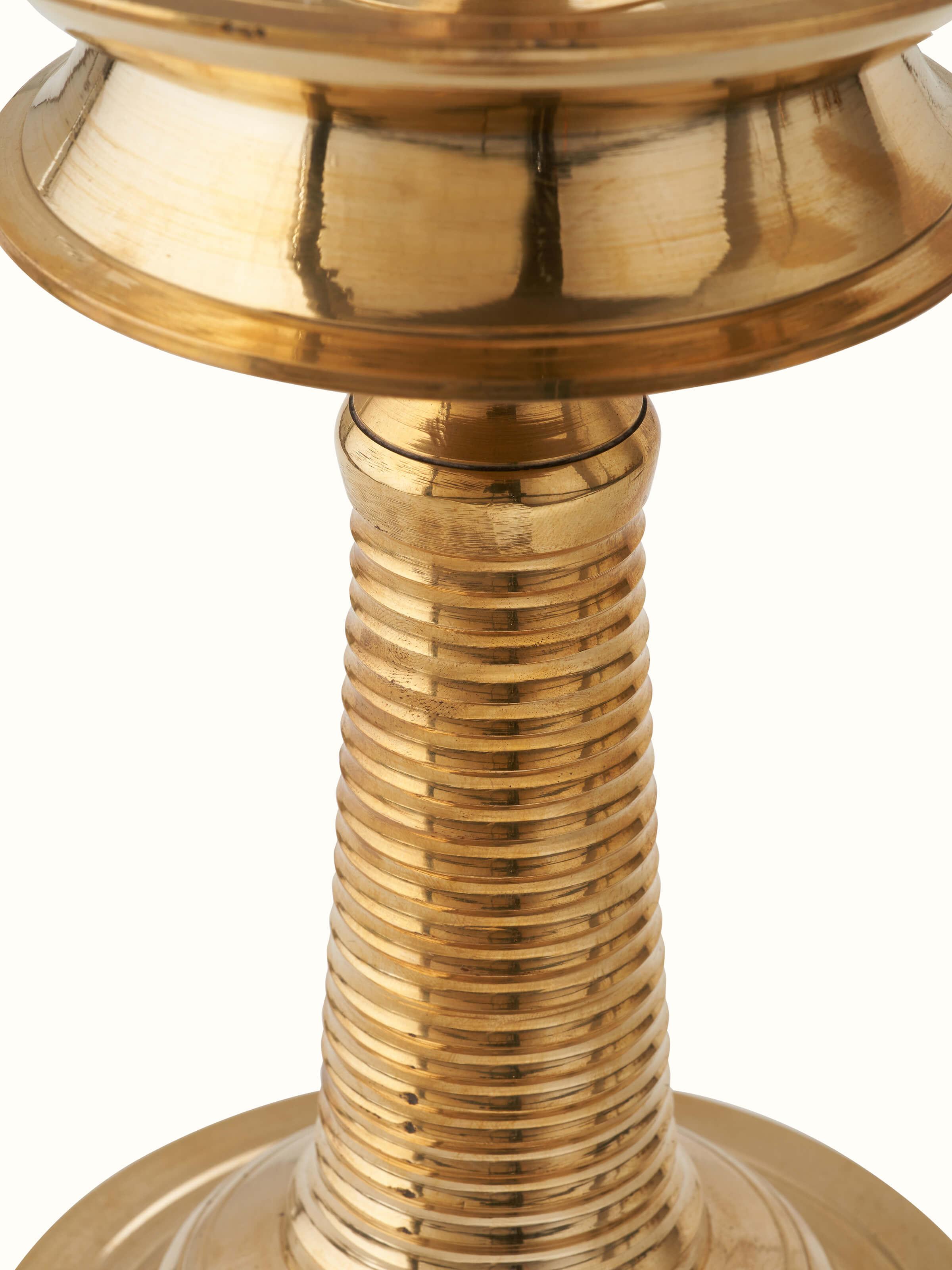 Close-up of brass-plated kuthu vilakku stand diya emphasizing craftsmanship