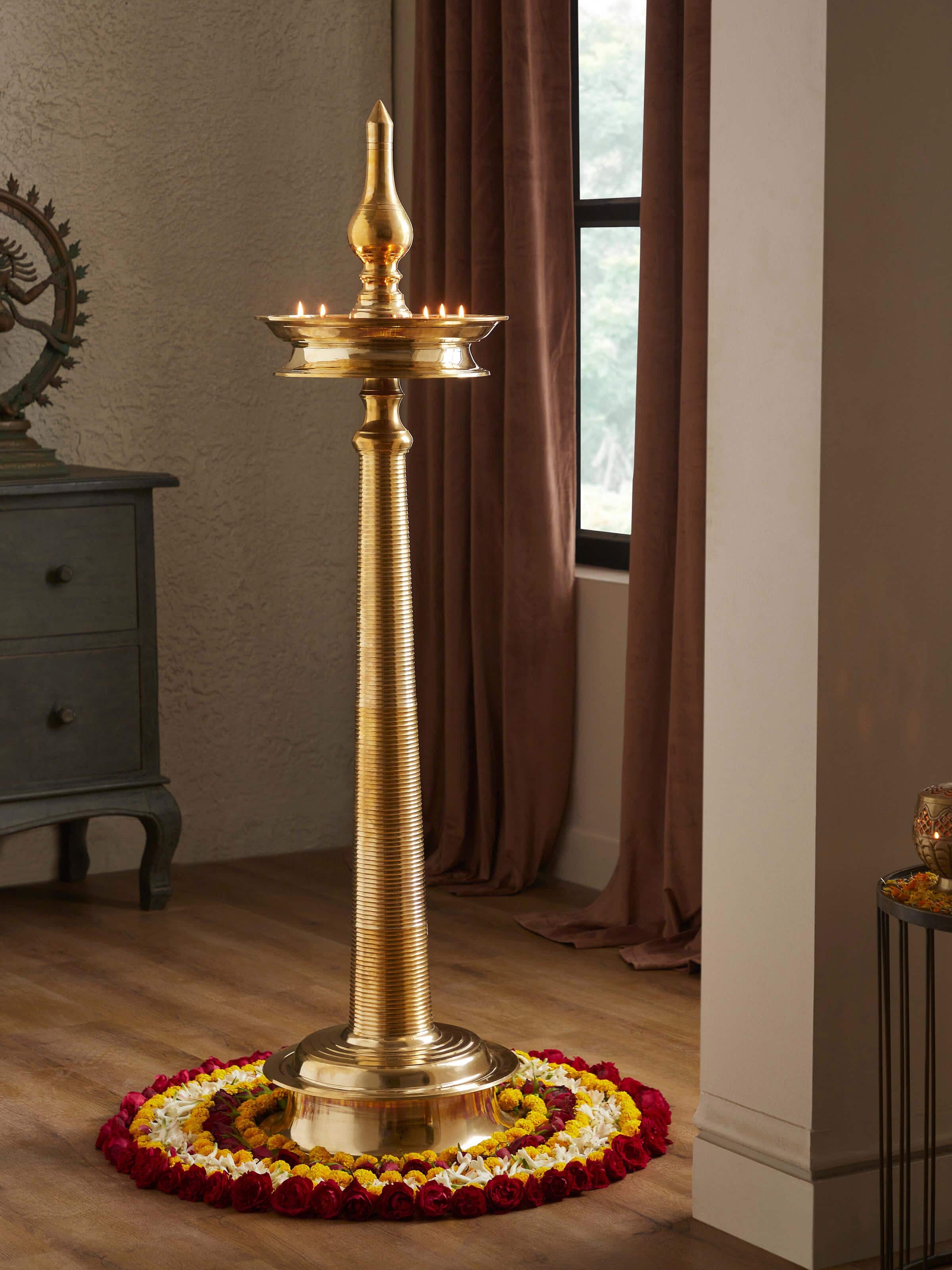 Close-up view of decorative brass samai vilakku stand diya, focusing on the detailed brass design and finish.