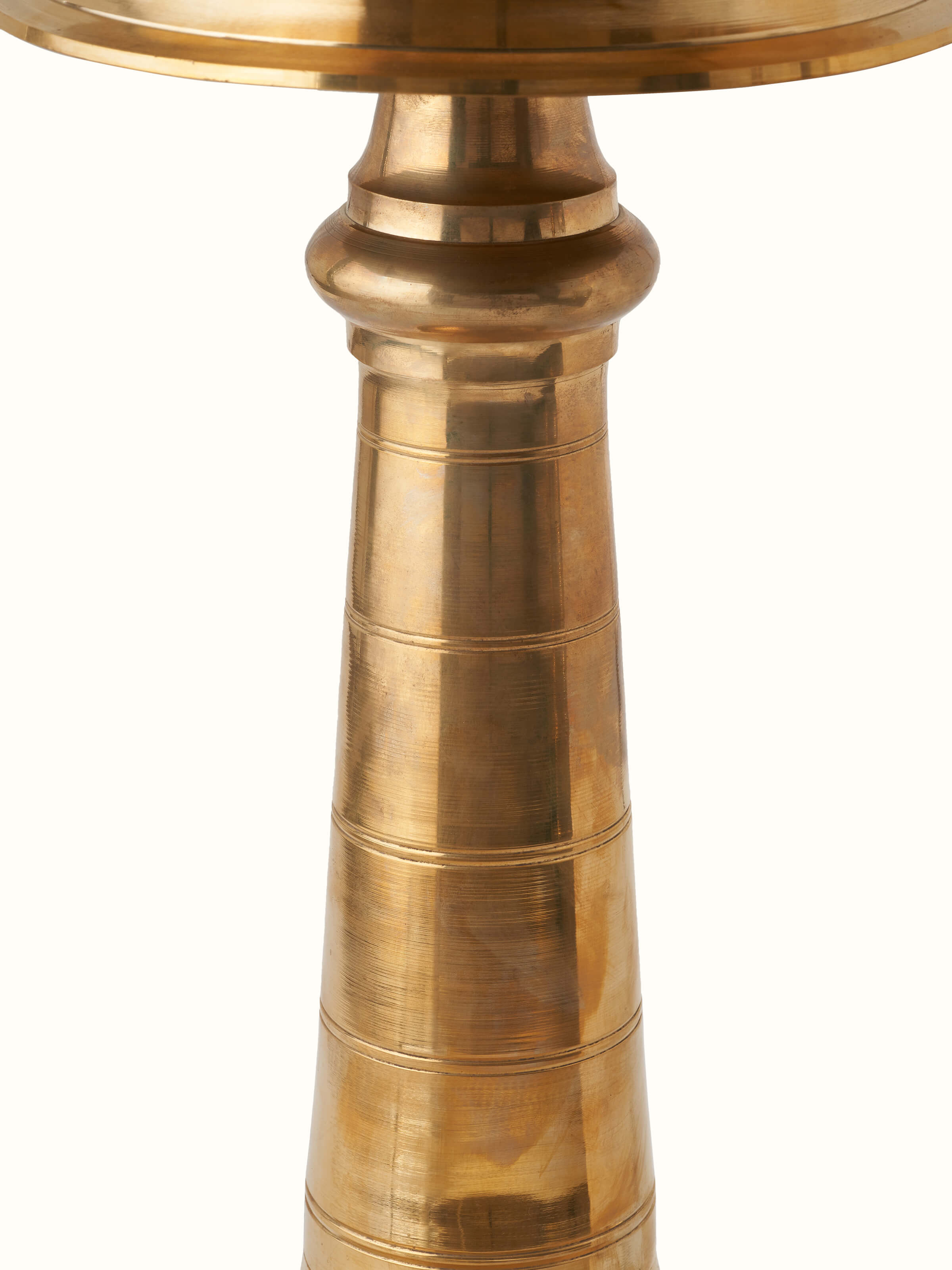 Angled view of brass samai vilakku stand diya, showcasing the traditional craftsmanship and decorative elements.