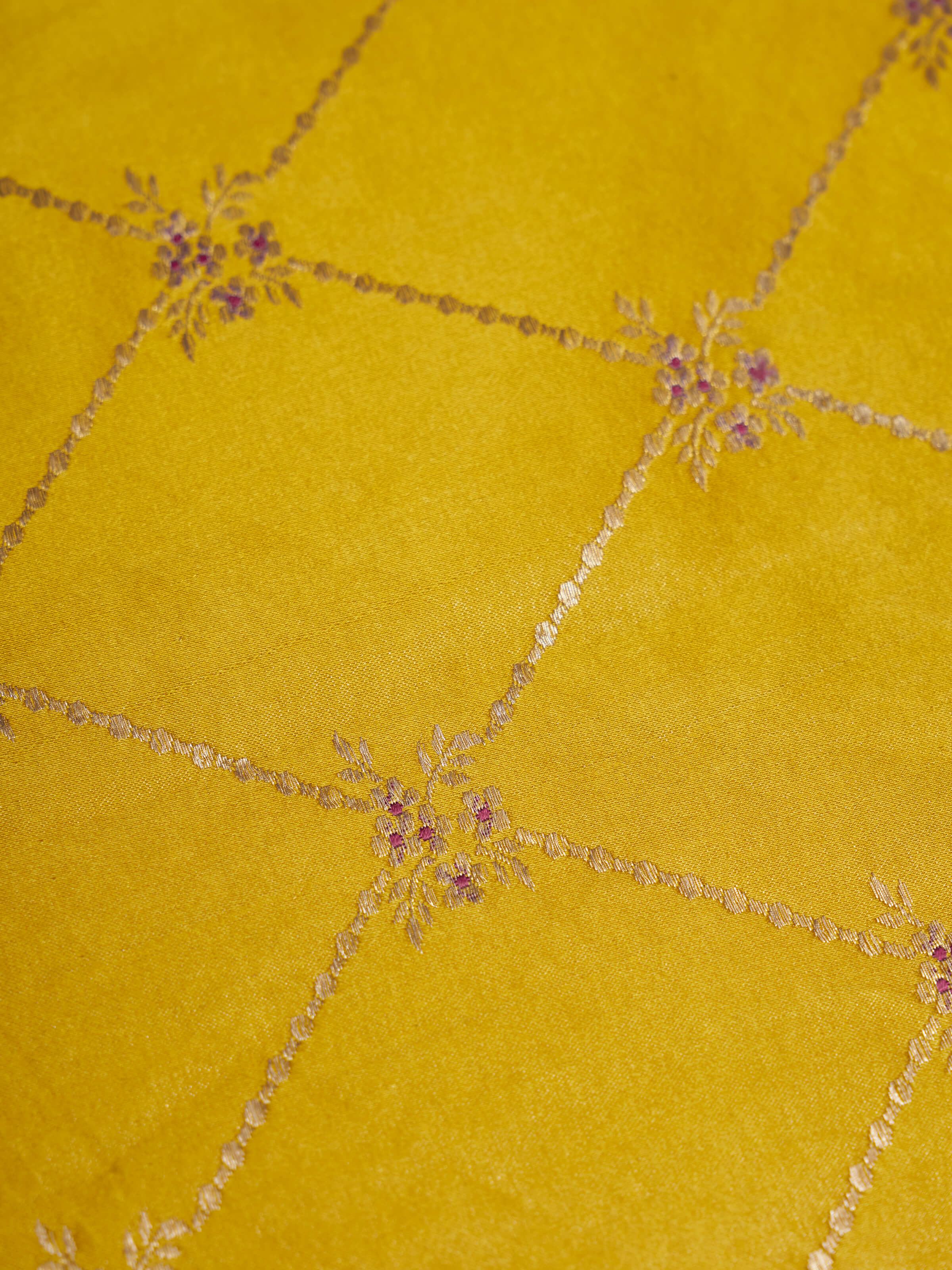 Lifestyle view of Mandana yellow Banarasi silk brocade table mats arranged on a traditional dining setup