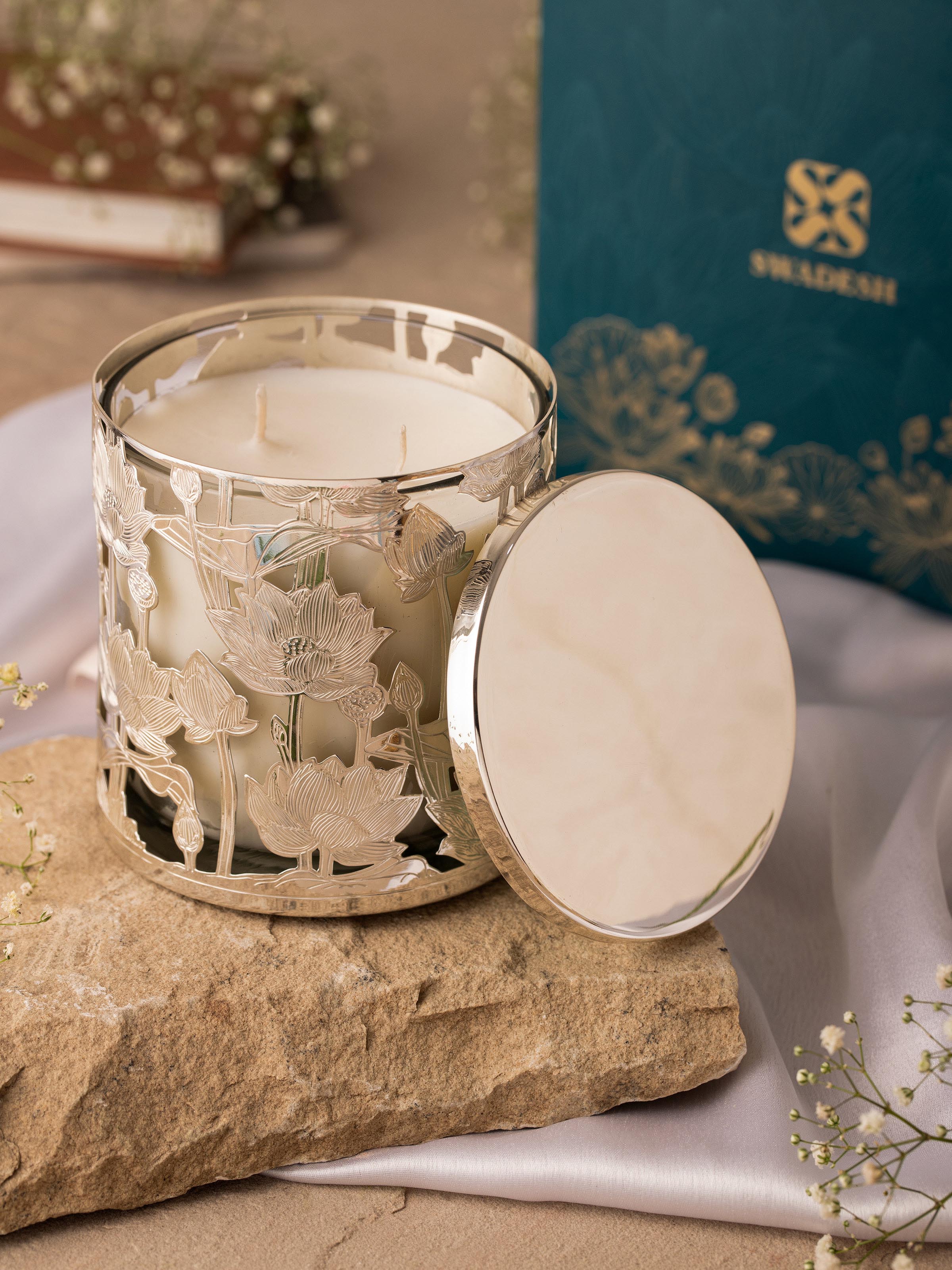 Side view of ornate silver-plated brass candle holder with a polished finish.