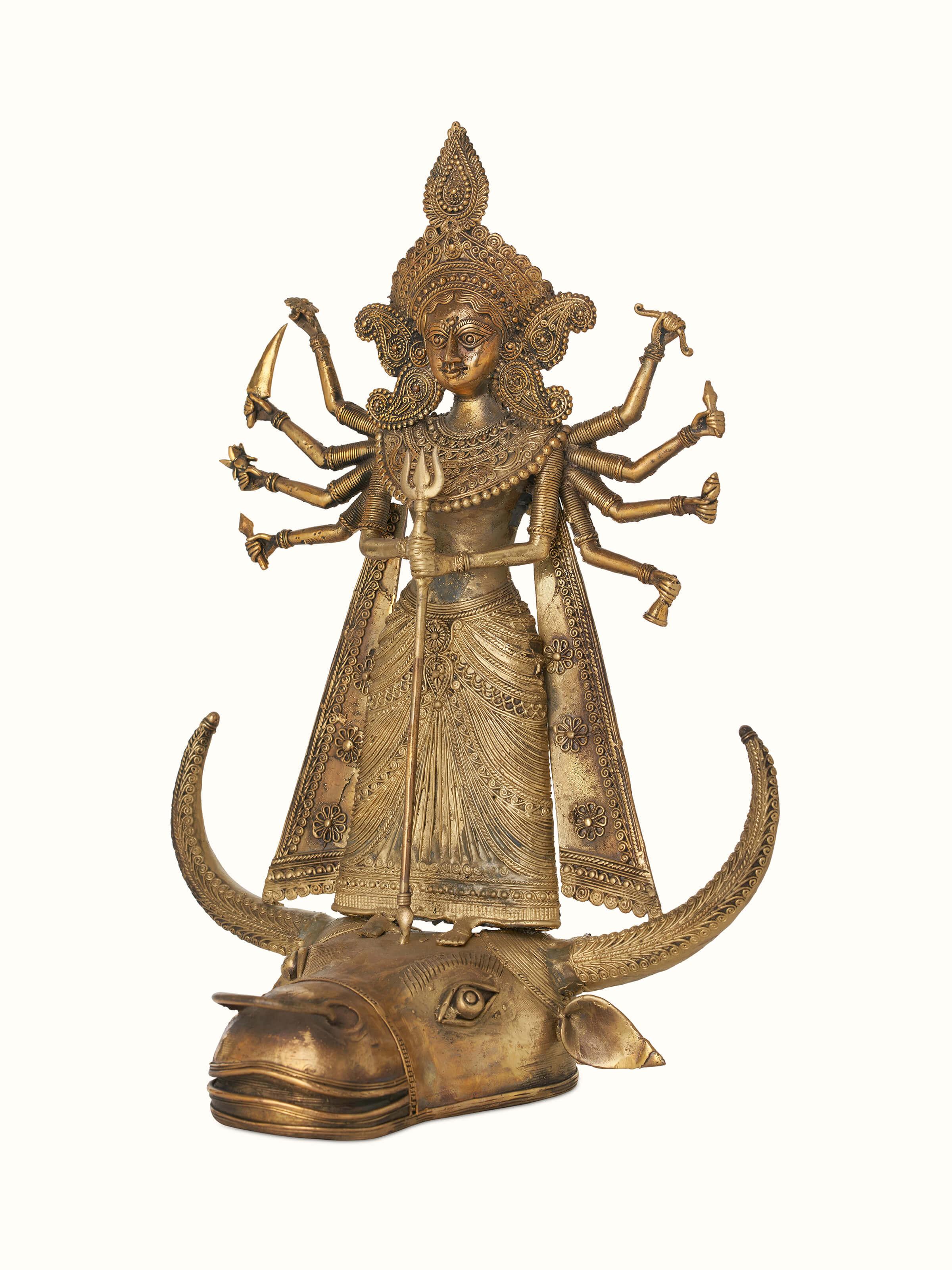 Close-up view of Brass dhokra Durga on bull idol in golden color focusing on detailed features and textures.