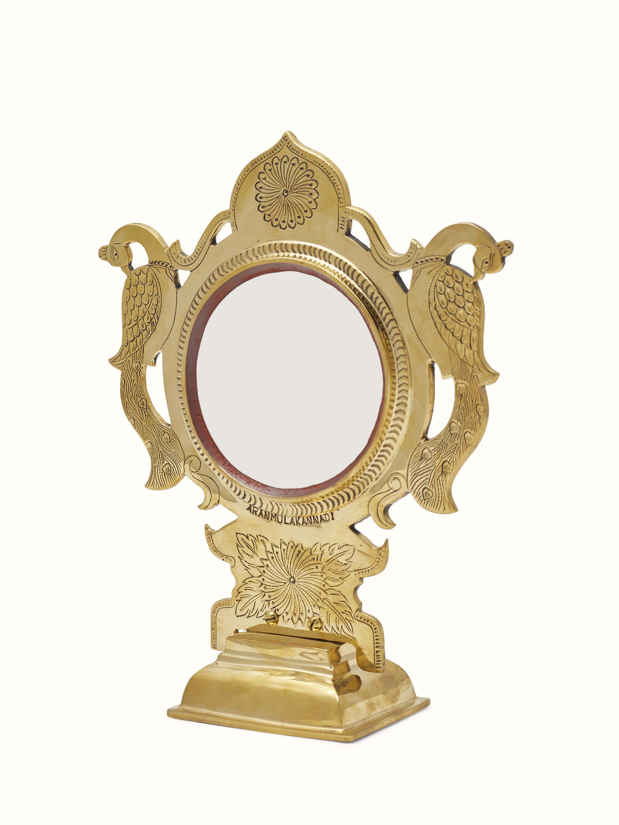 Angled view of Traditional Aranmula Kannadi brass mirror highlighting its polished brass frame and detailed design