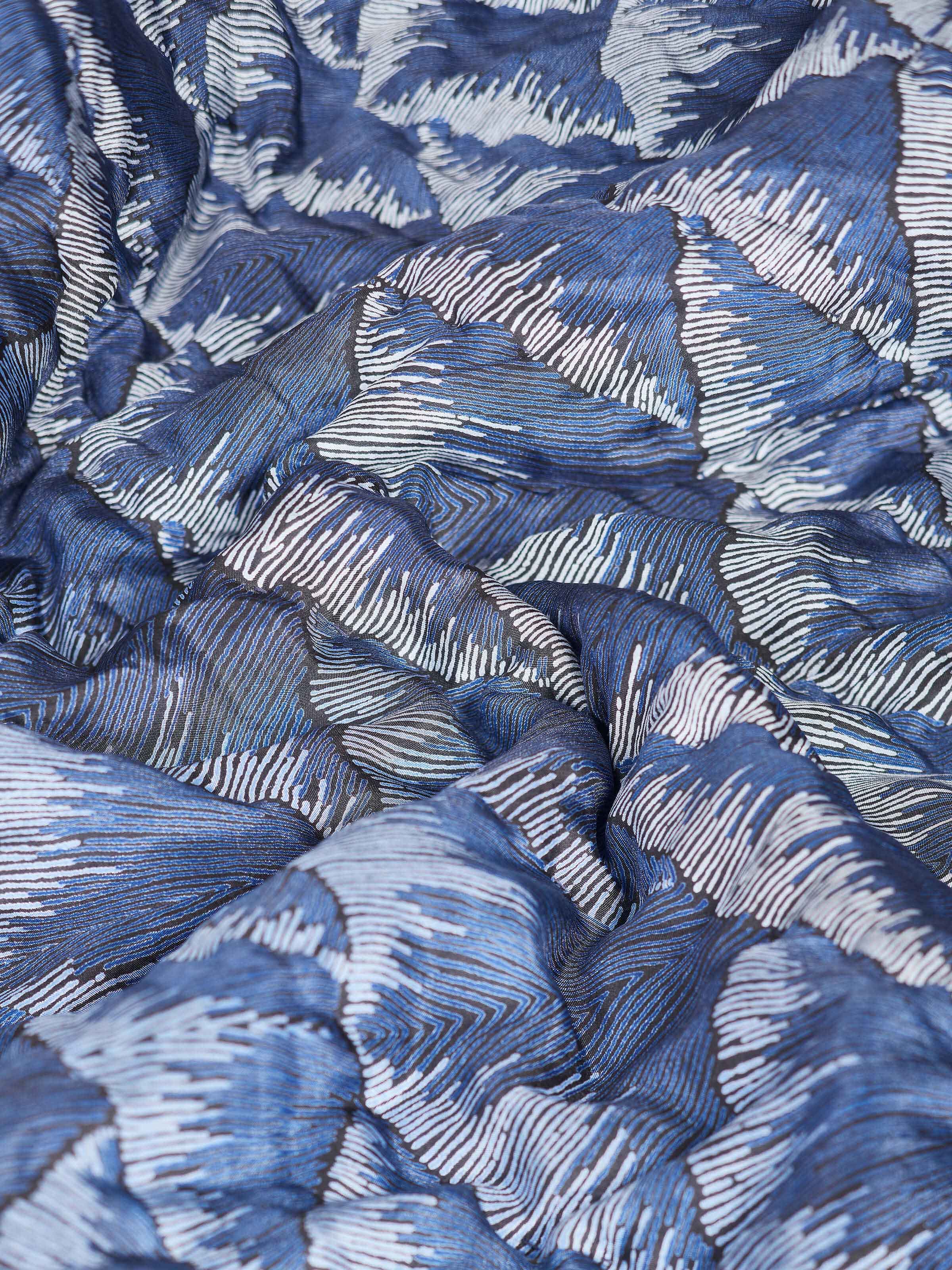 Parvat indigo ombre quilt folded, displaying its design and texture