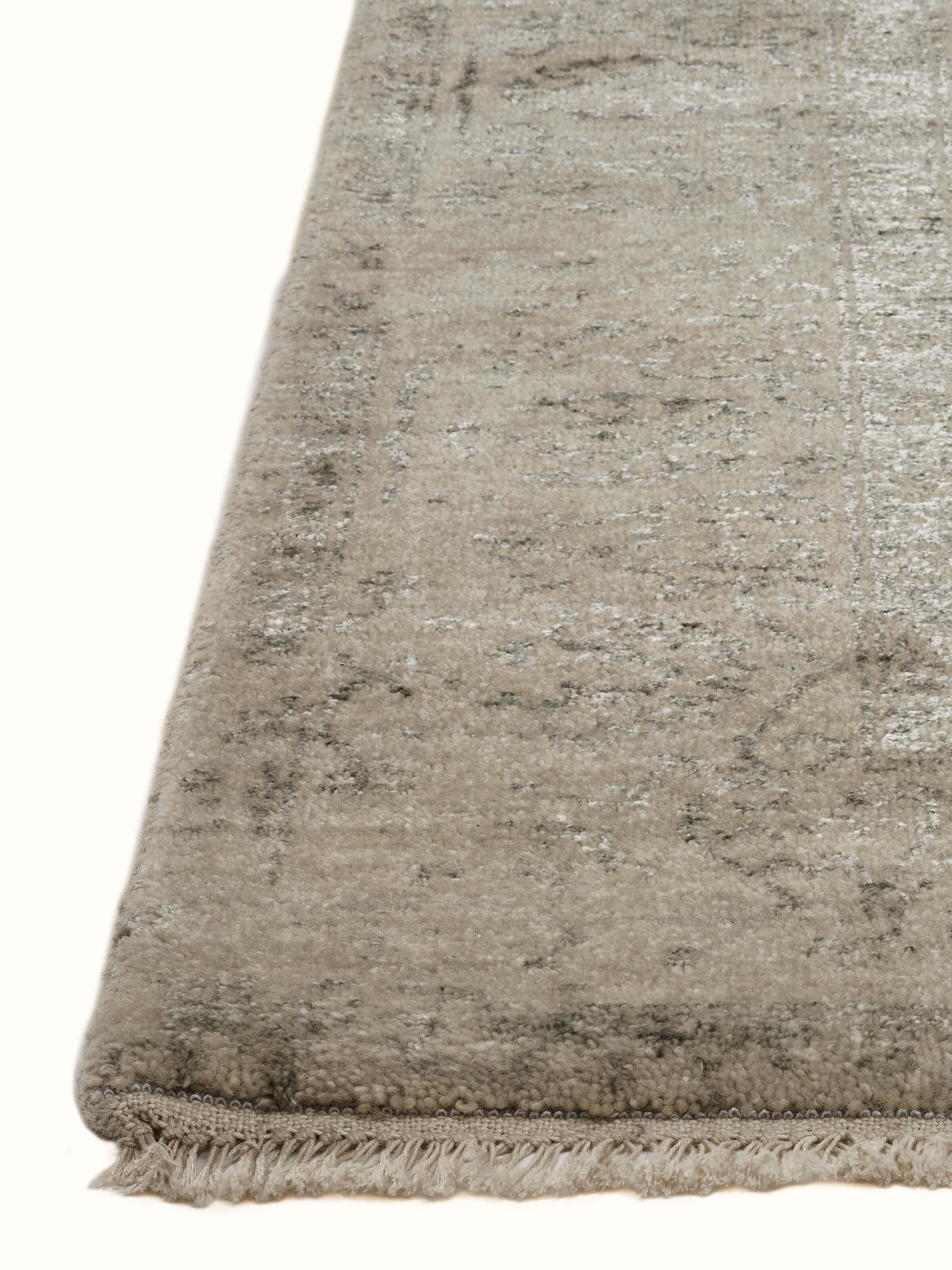 Detailed image of the charcoal Agra wool and viscose hand-knotted carpet with a focus on the distressed transitional design