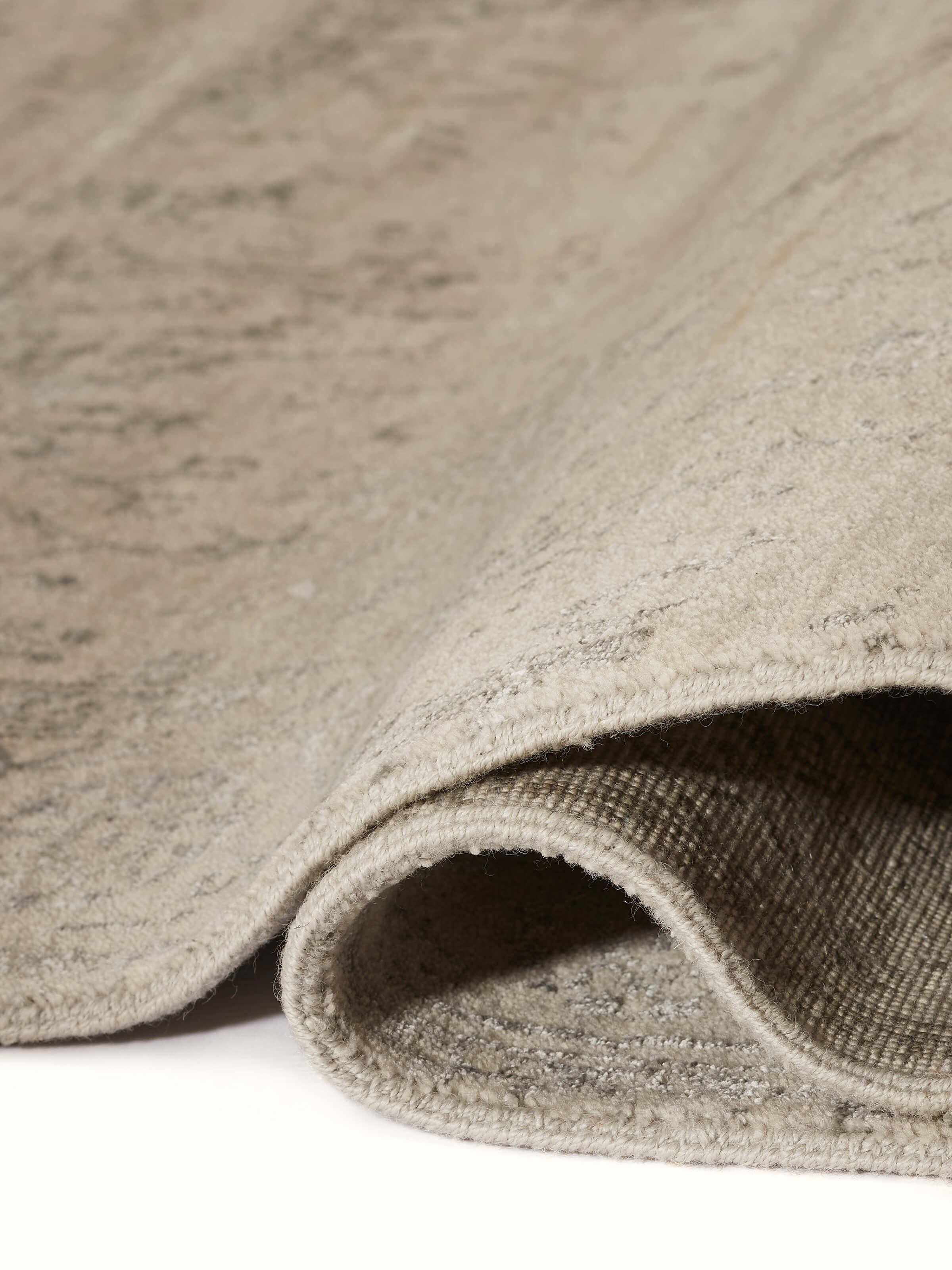 Close-up of the wool and viscose hand-knotted carpet showing the distressed transitional pattern and its luxurious texture