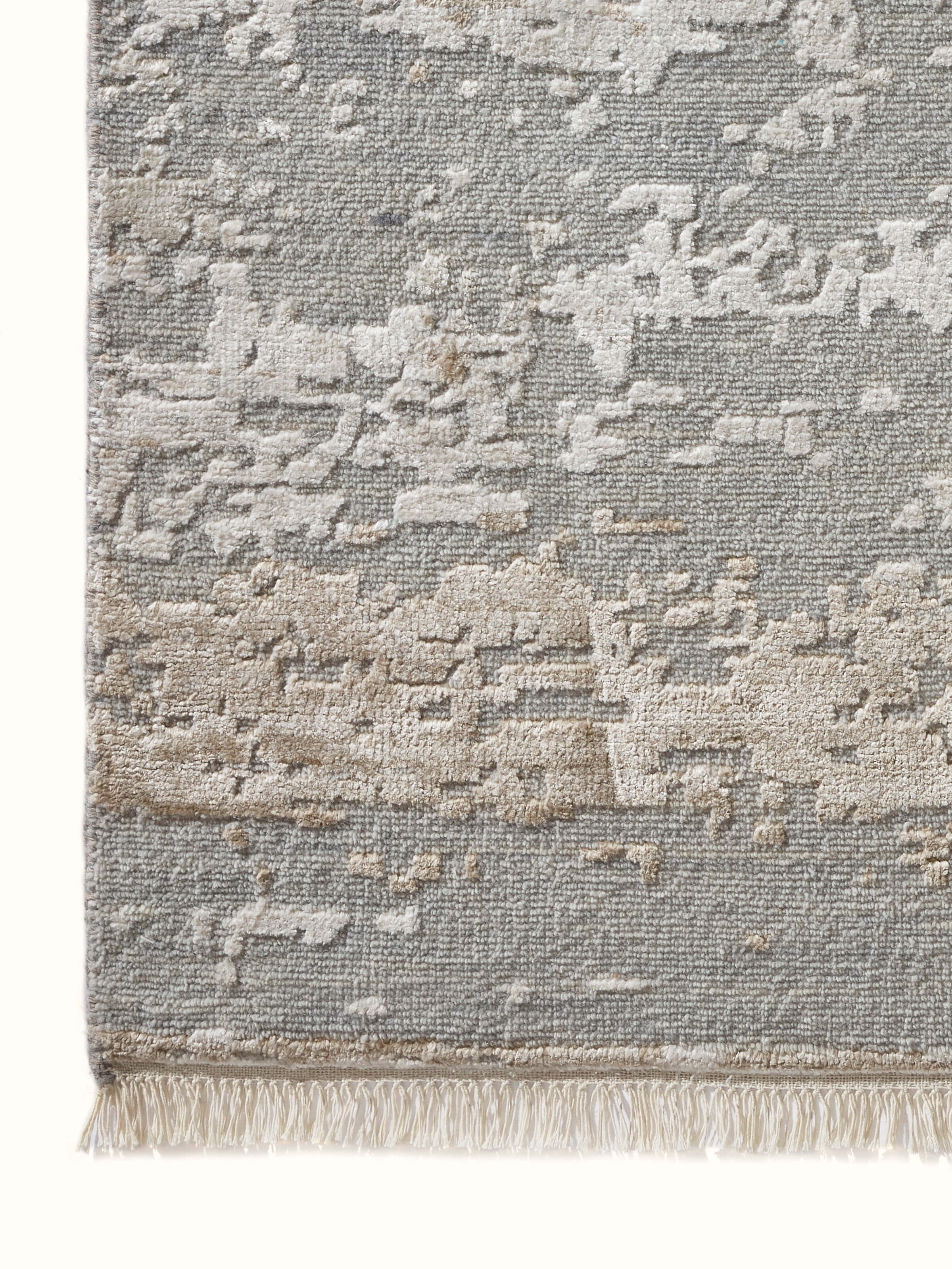 Close-up texture of abstract grey taupe hand-knotted Agra wool viscose rug