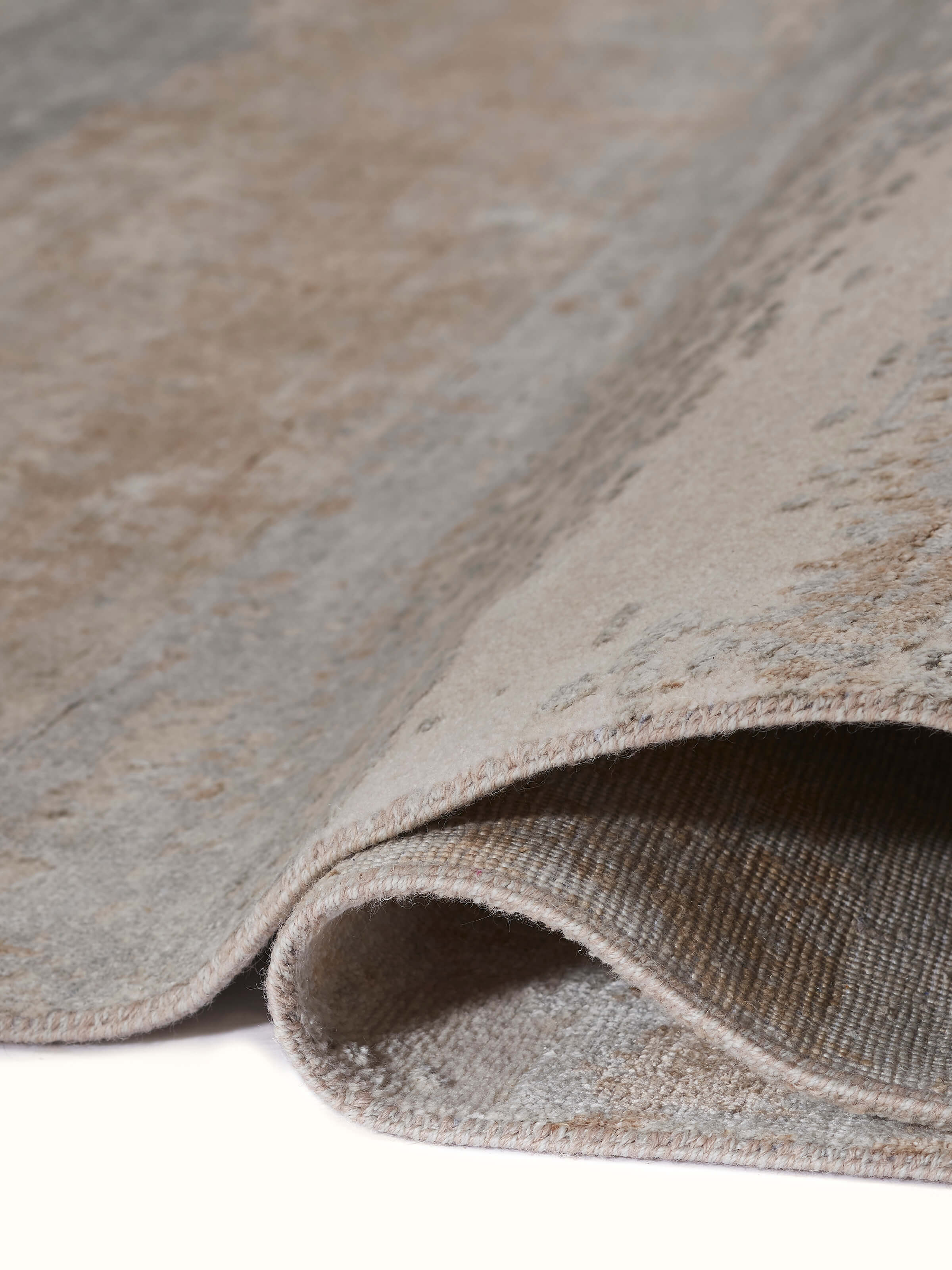 Side view of grey beige Agra hand-knotted carpet showcasing artistic texture