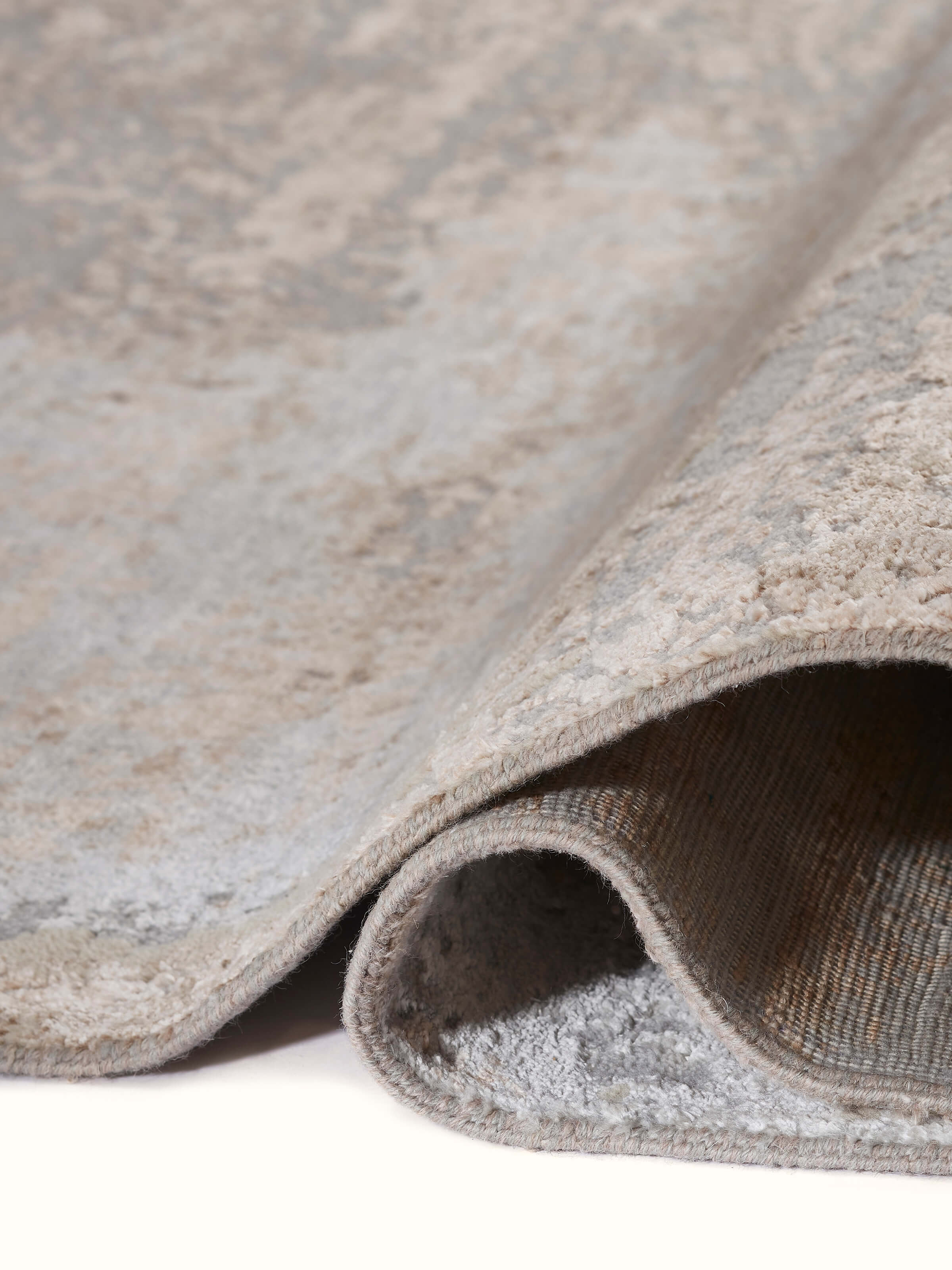 Detailed shot of Abstract modern grey blush wool & viscose hand-knotted carpet showing craftsmanship and weave