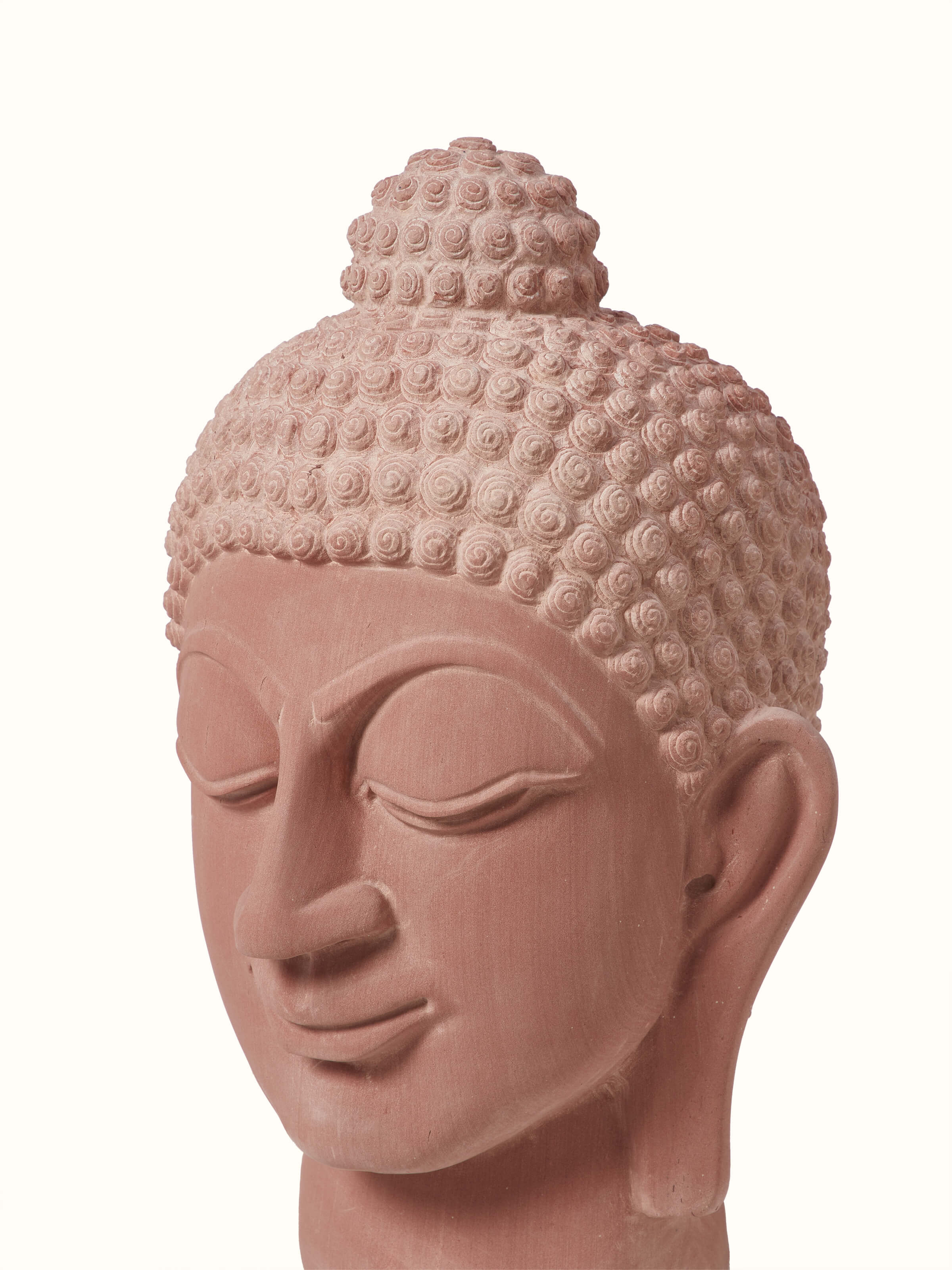 Close-up of serene carved stone Buddha face idol, focusing on the fine details and craftsmanship of the carving