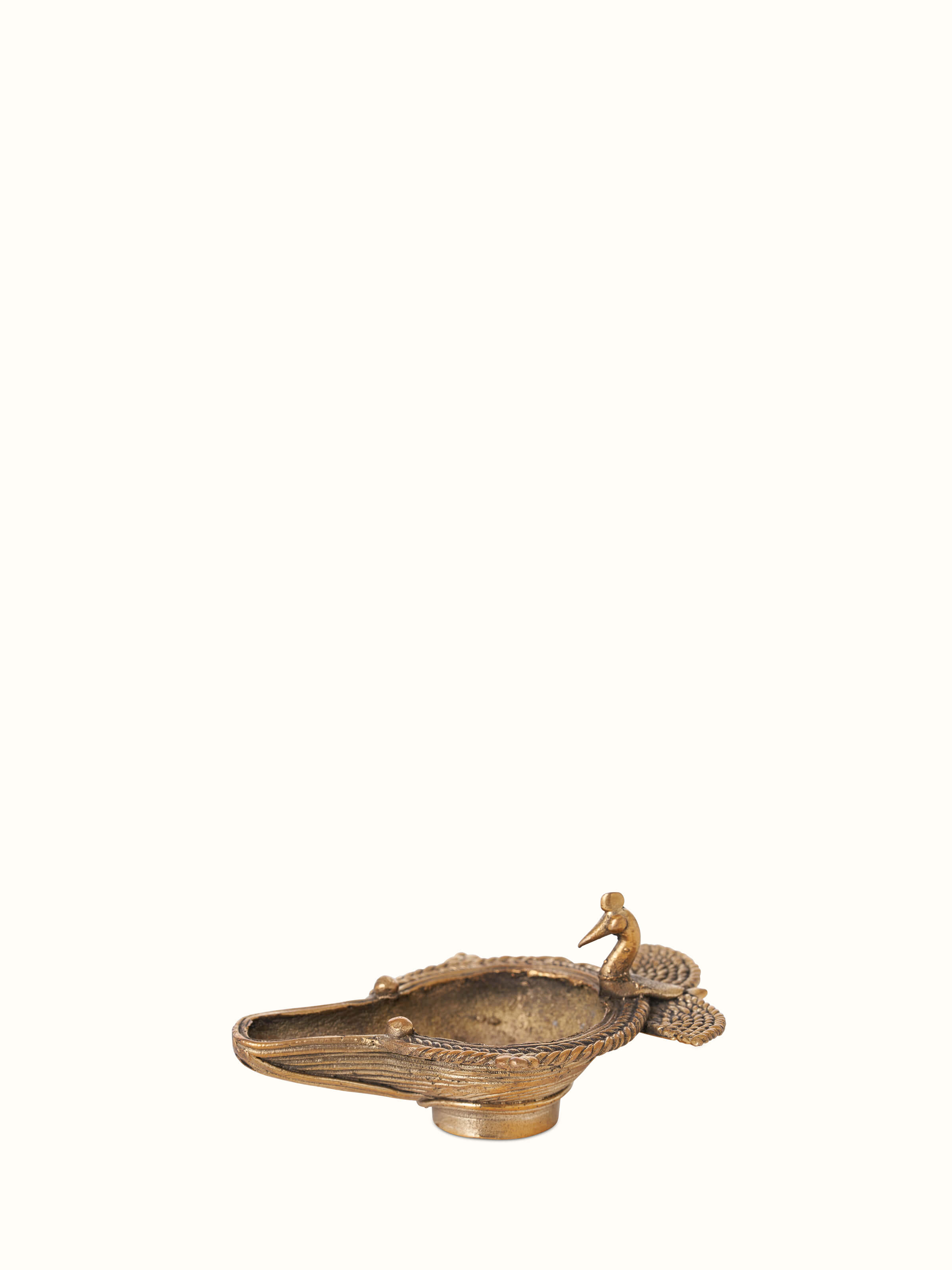 Side view of the antique brass dhokra peacock diya showing its ornate peacock design.