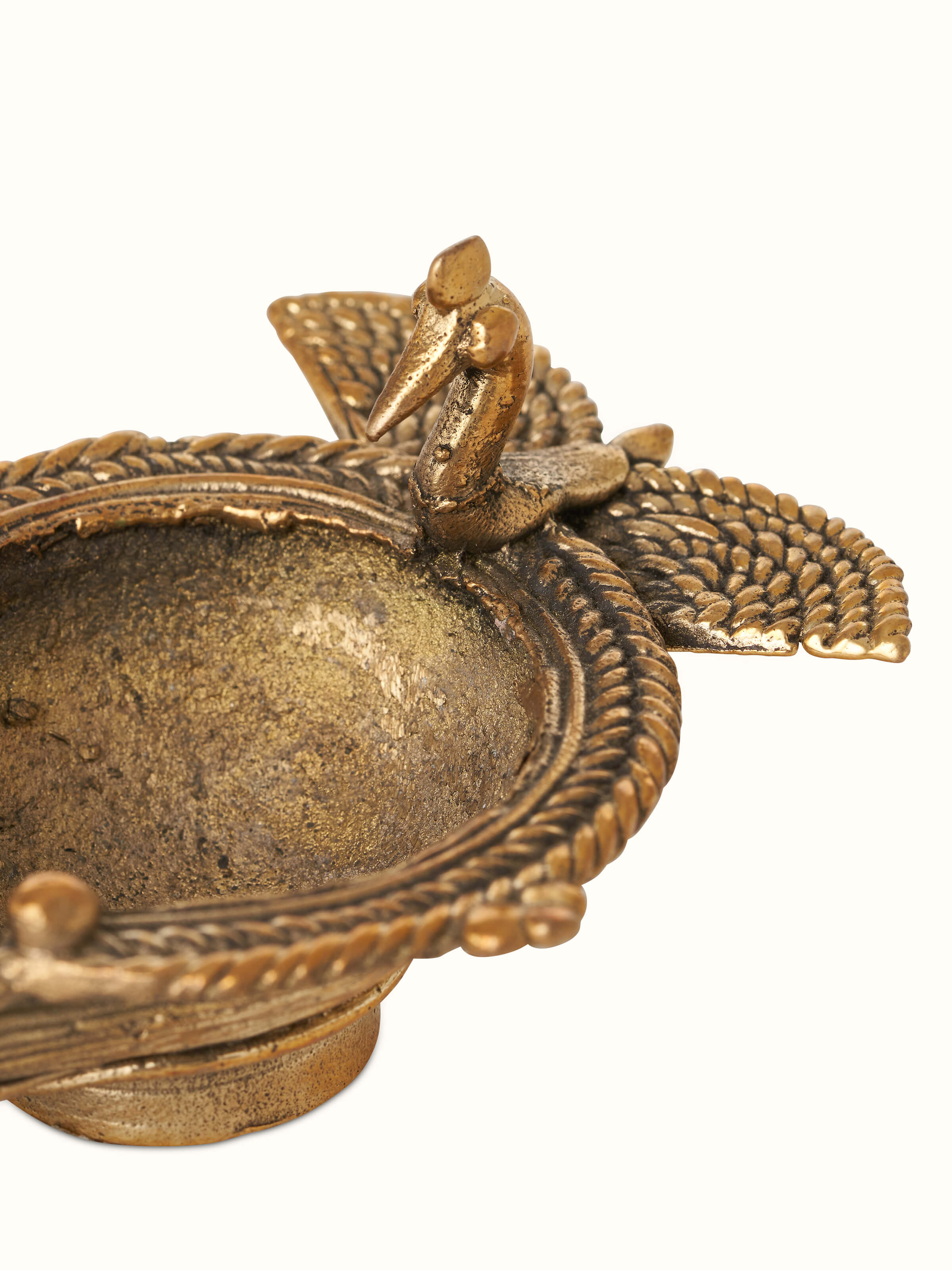 Full view of the antique brass dhokra peacock diya showcasing its traditional brasswork.