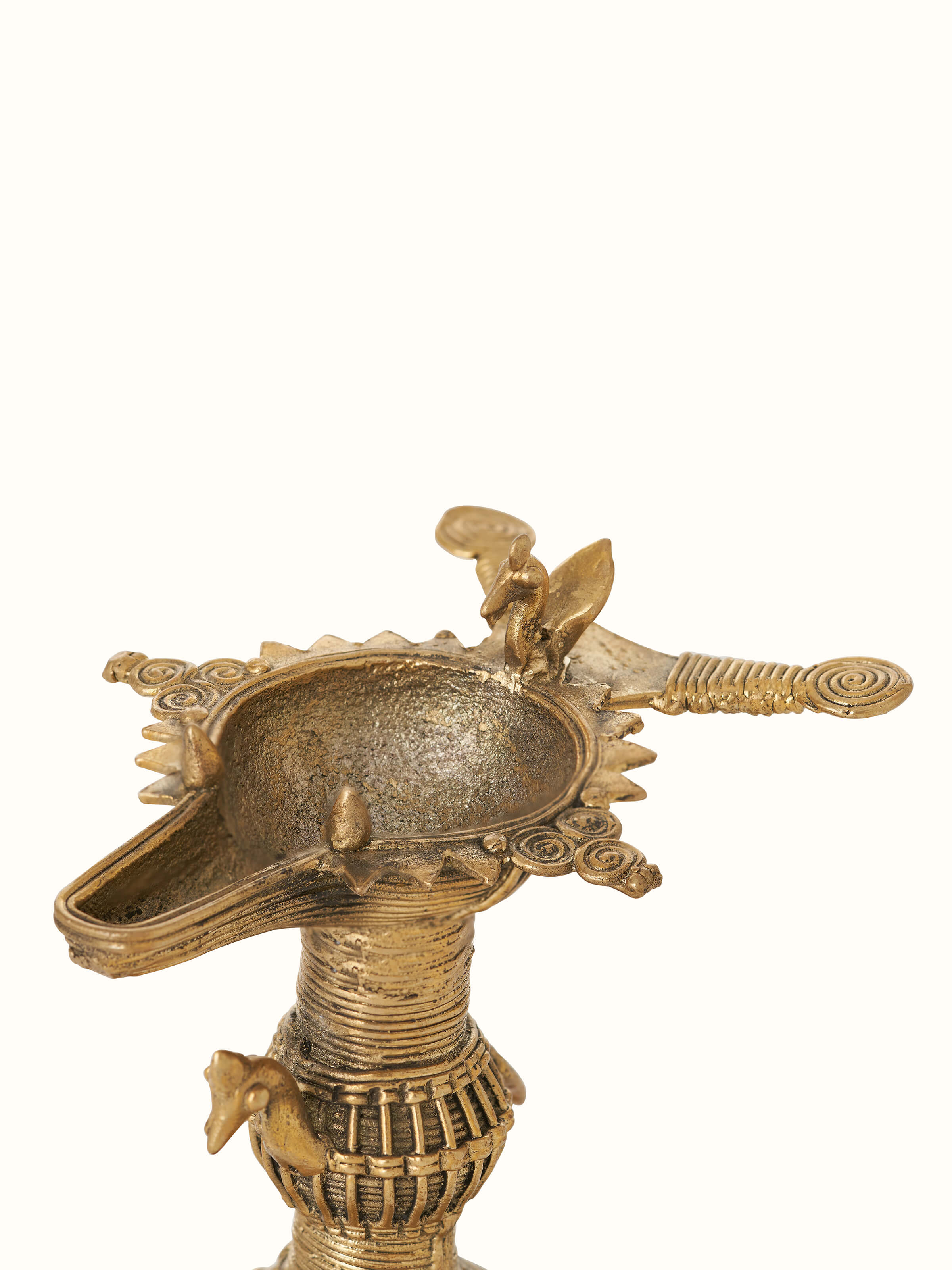Close-up view of antique brass dhokra diya, highlighting its decorative patterns and brass finish