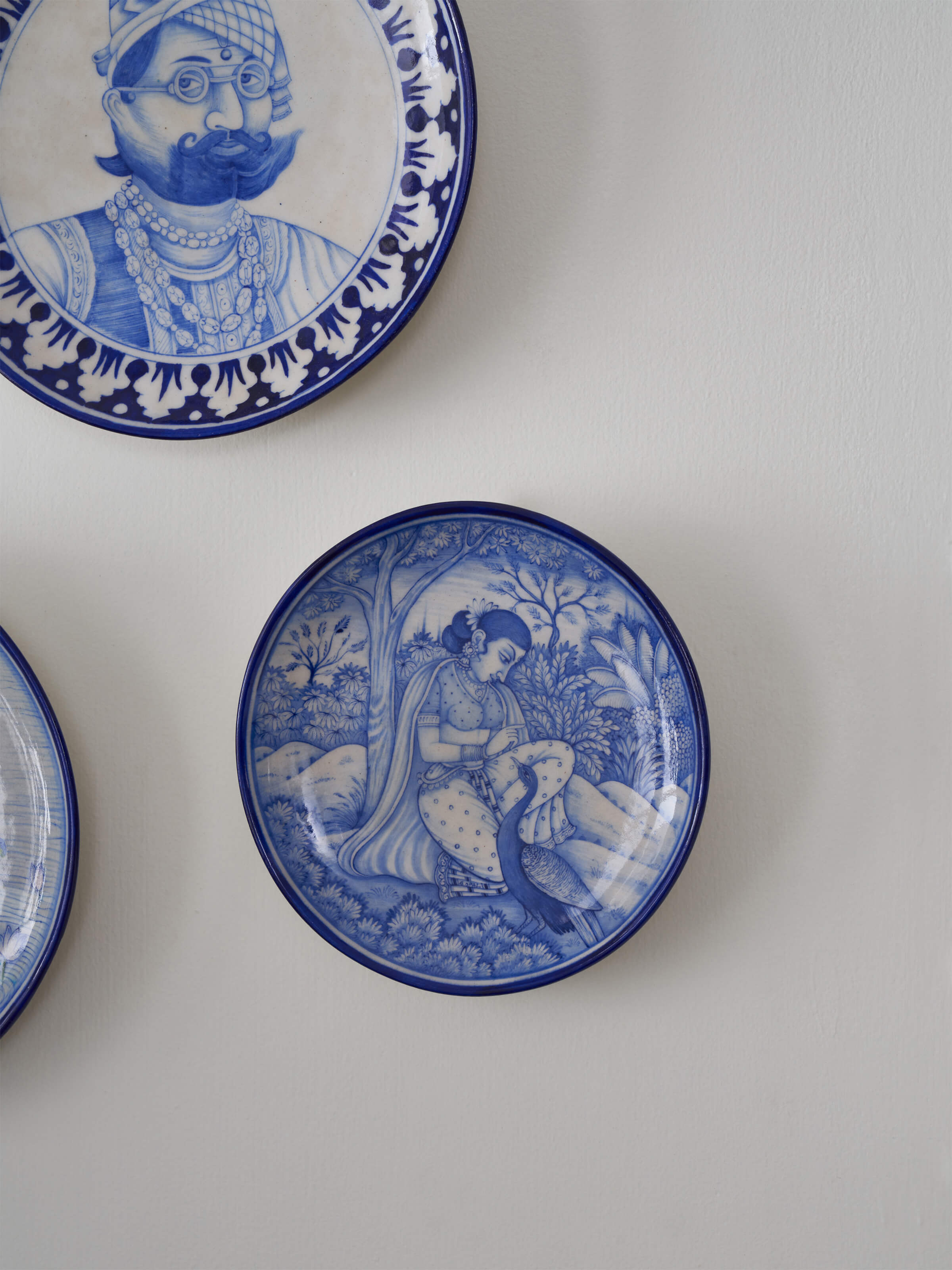 Close-up view of Blue Pottery Woman under Tree Display Plate by Swadesh showcasing fine detailing and vibrant color.