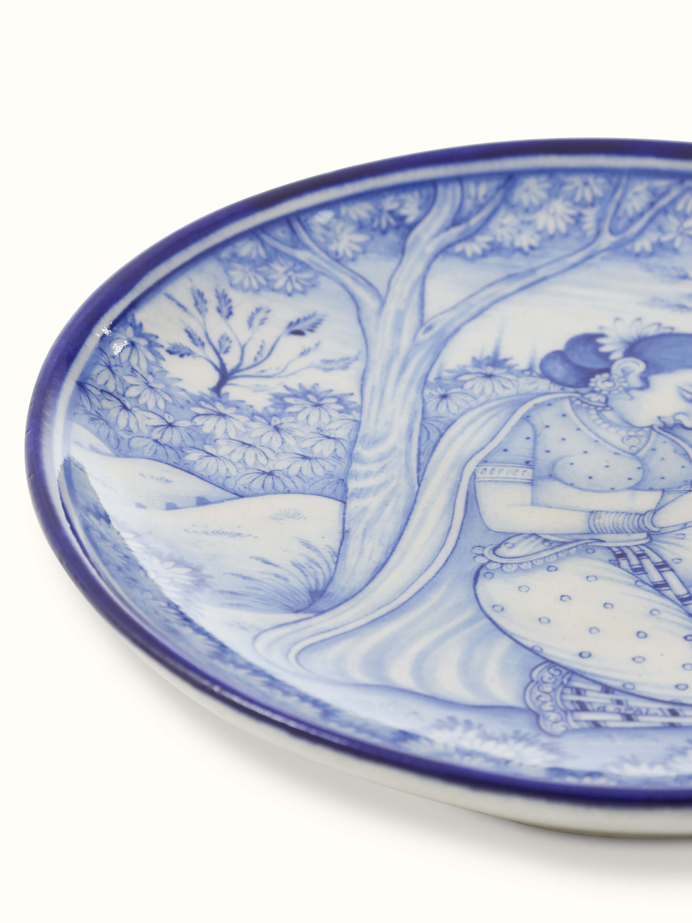 Side view of Blue Pottery Woman under Tree Display Plate by Swadesh highlighting the graceful design and vibrant pottery work.