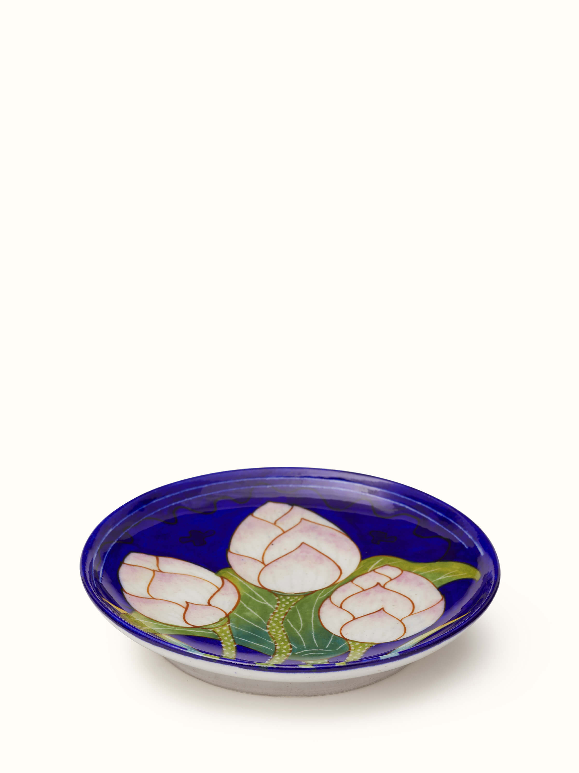 Close-up view of Blue Pottery Three Flowers Display Plate from Swadesh, focusing on the floral design and vibrant ceramic colors.