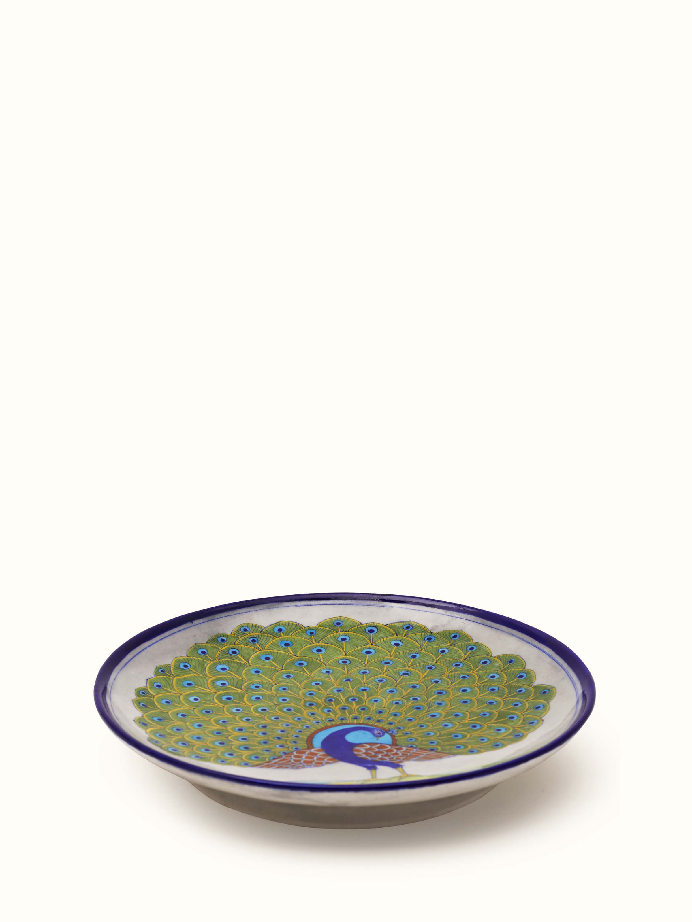 Angle view of Blue pottery peacock display plate