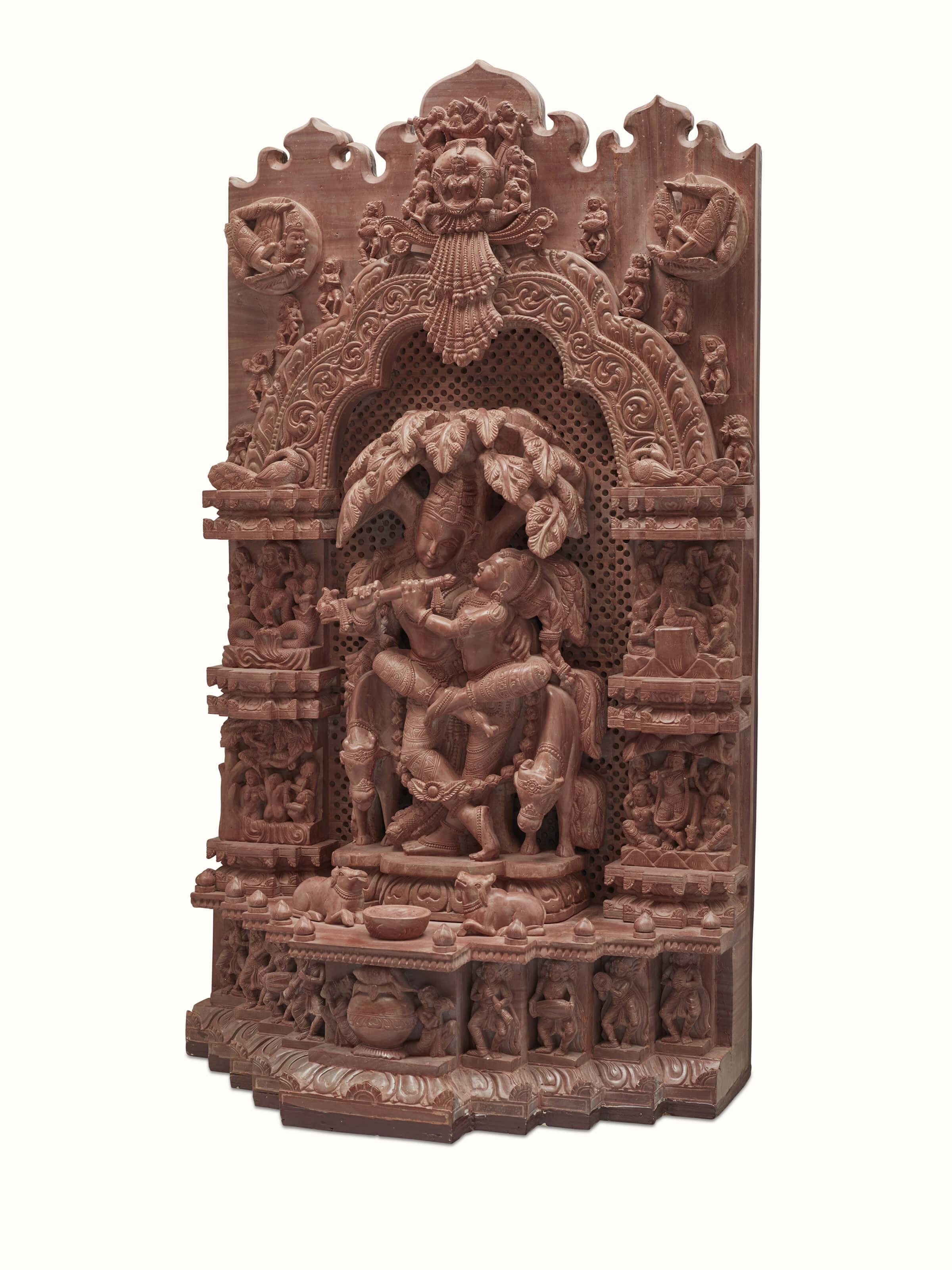 Close-up of carved stone Radha & Krishna raasa idol showing detailed features.