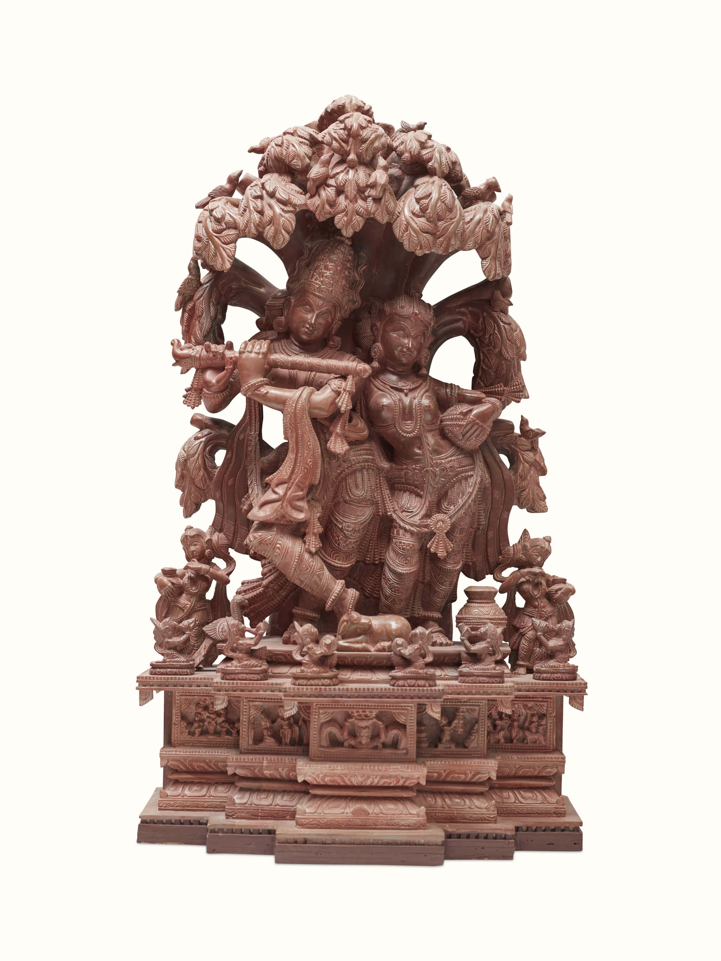 Front view of the carved stone Radha & Krishna idol under a tree.