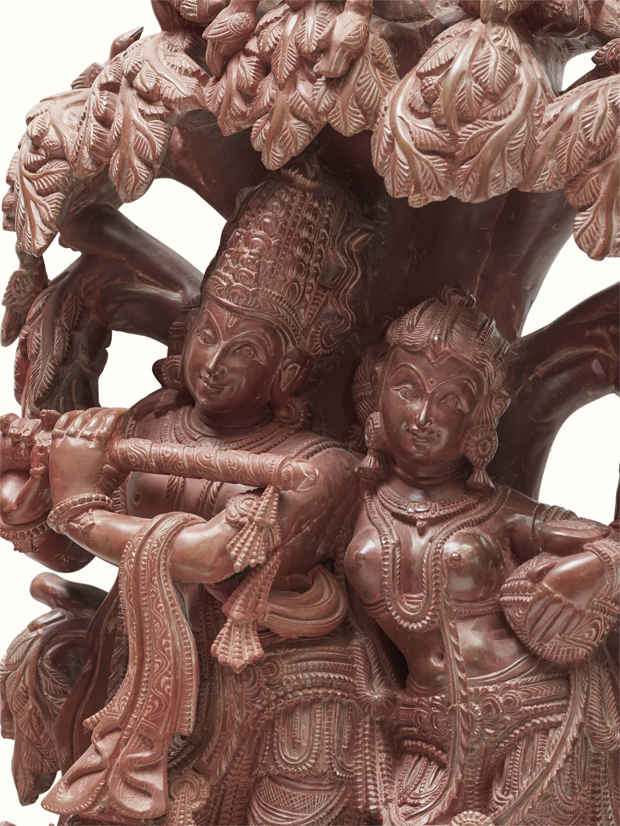 Detailed close-up of the Radha & Krishna carved stone idol under the tree.