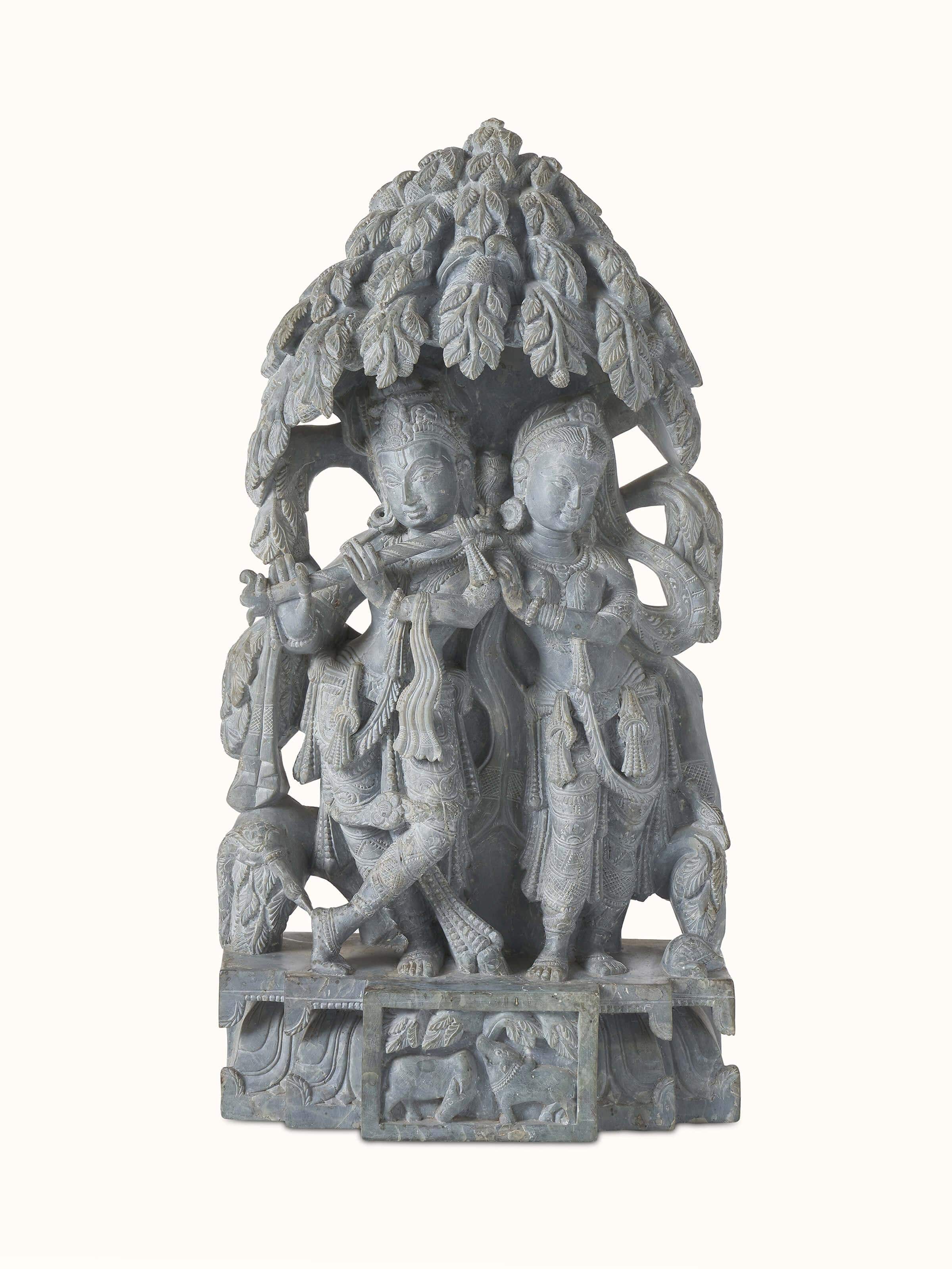 Front view of carved stone Radha & Krishna in love idol capturing intricate details and artistic expression.